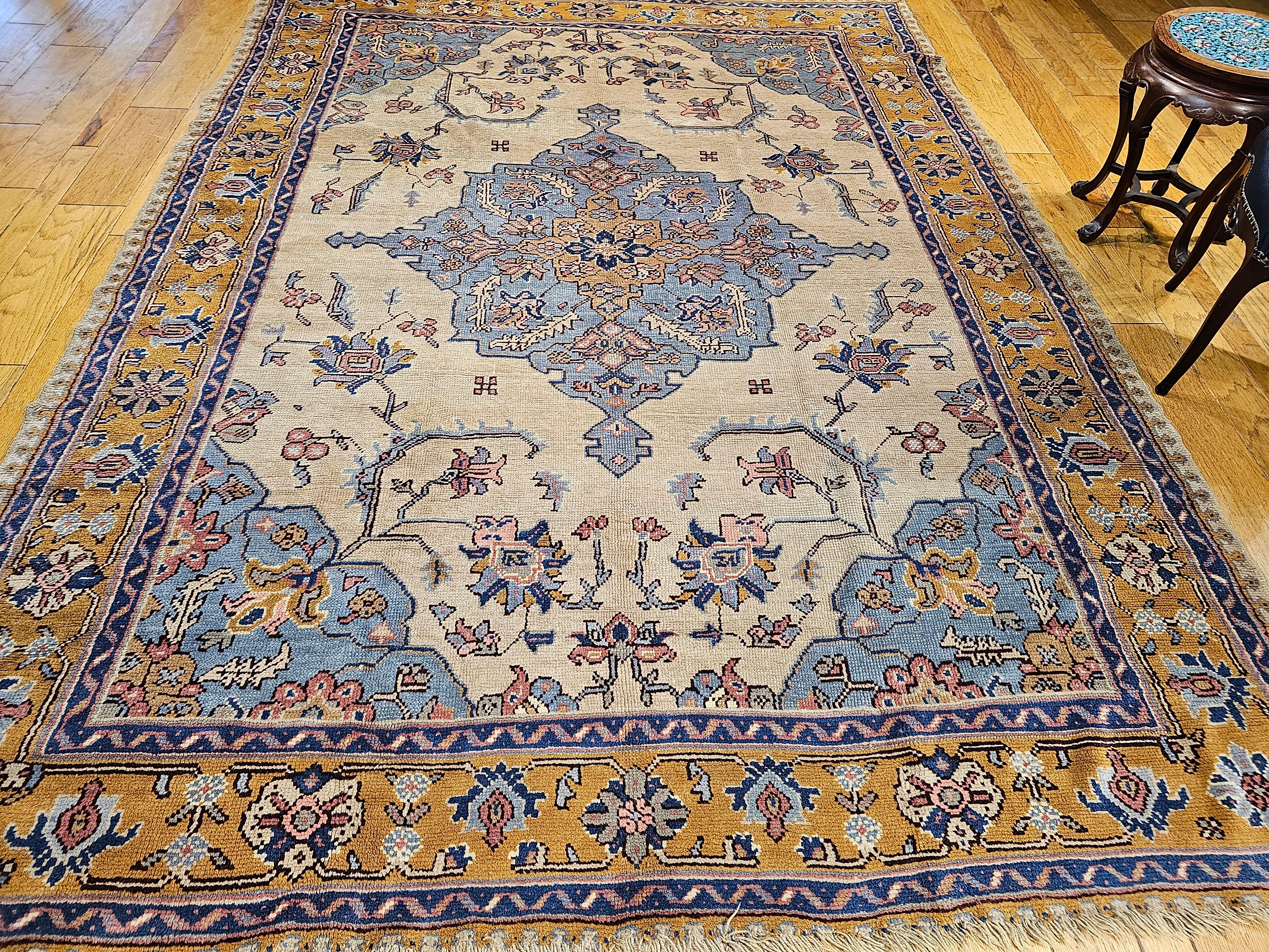 Türkischer Vintage Oushak mit geometrischem Heriz Serapi-Muster in Elfenbein, Babyblau und Gelb aus den frühen 1900er Jahren. Ein blassblaues zentrales Medaillon ist in ein wunderschönes cremefarbenes Feld in einem offenen Design eingefasst. Die