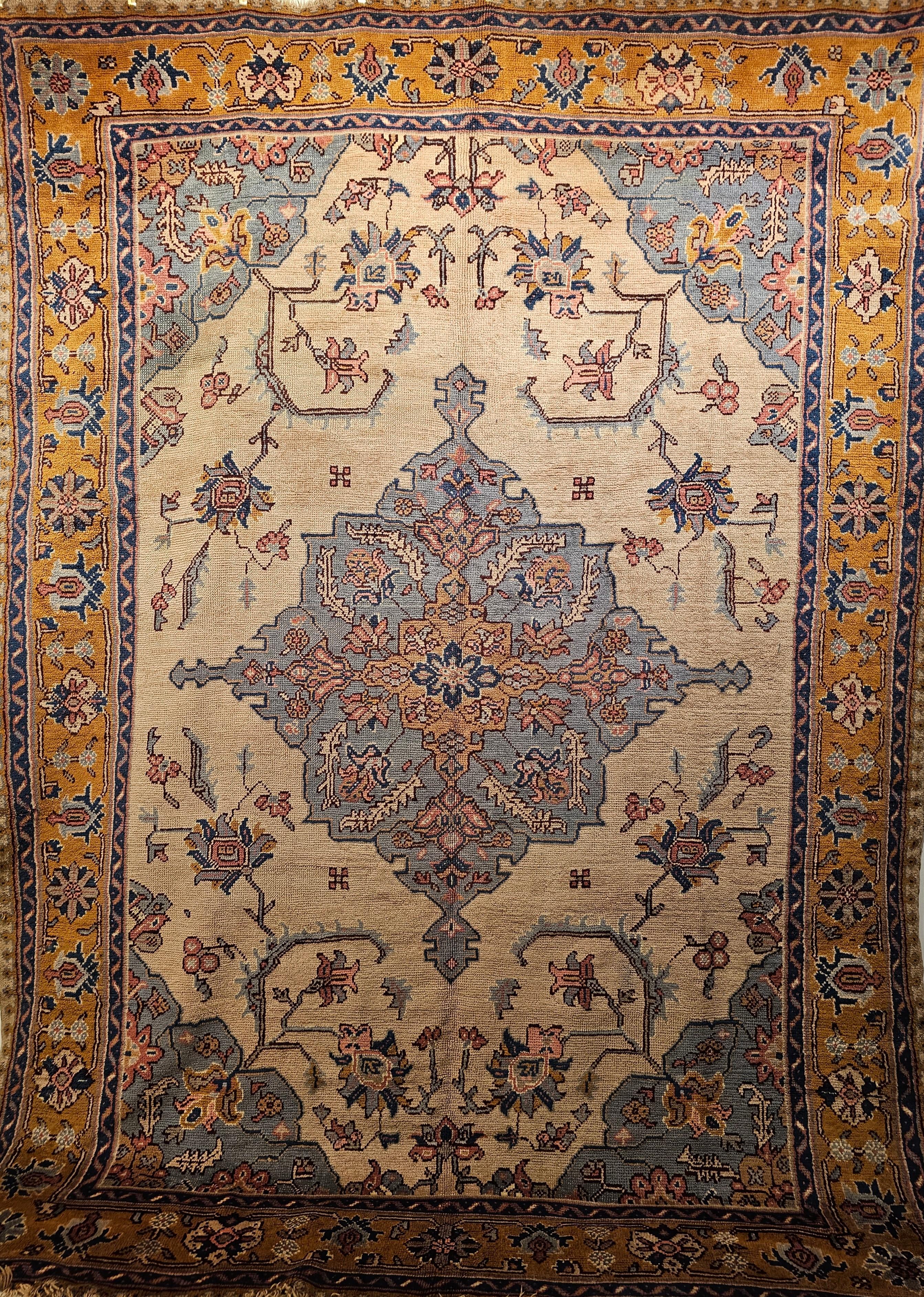 Vintage Turkish Oushak in a geometric Heriz Serapi pattern in ivory, baby blue and yellow colors from the early 1900s. A pale baby blue central medallion is set in a wonderful cream color field in an open design. The border is in saffron yellow.