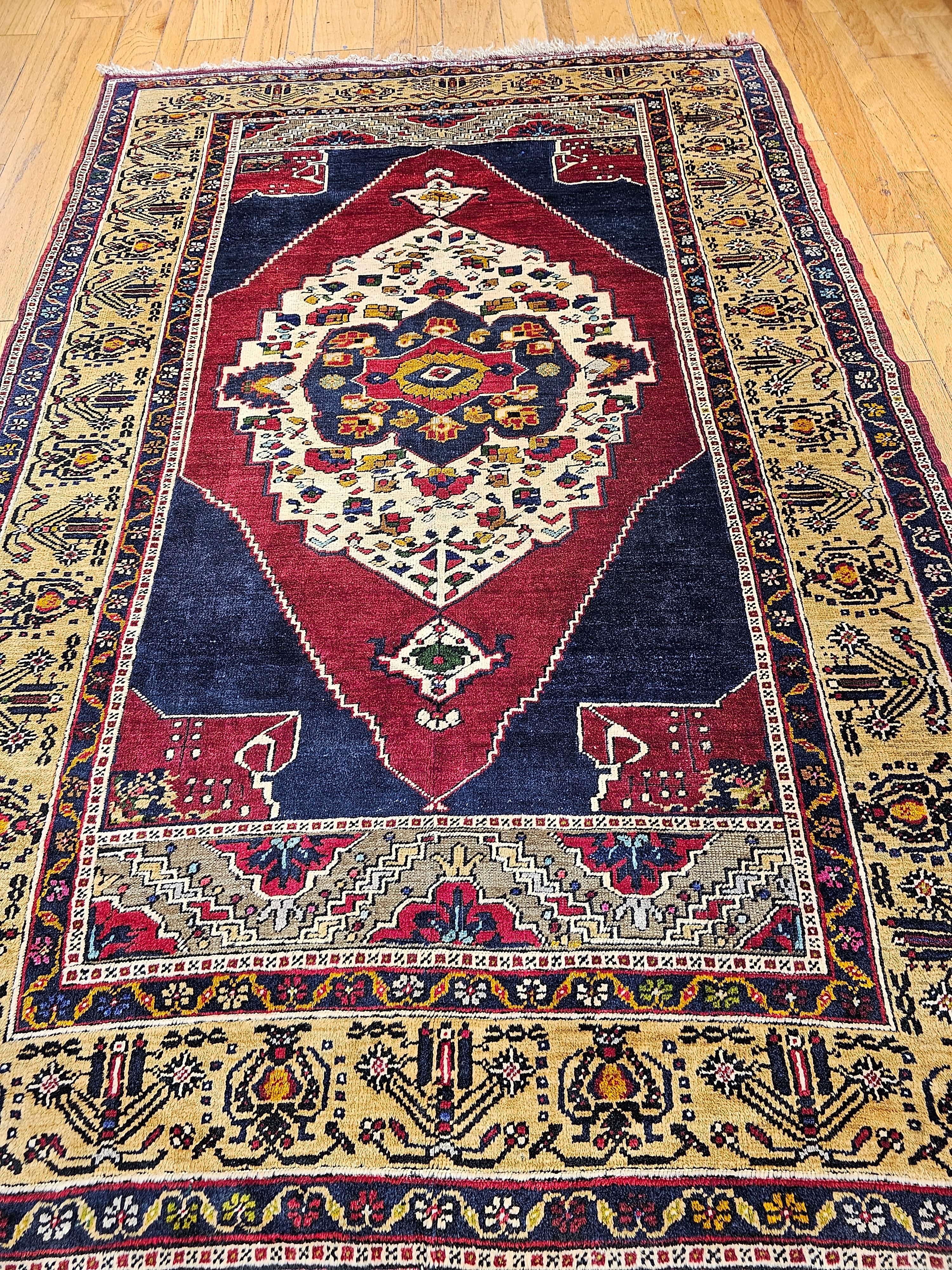 Magnifique tapis turc d'Anatolie noué à la main, de type Oushak, datant du deuxième quart des années 1900.  Le tapis a un fond bleu foncé et rouge qui contient les médaillons intérieurs et extérieurs.  La particularité de ce tapis est son magnifique