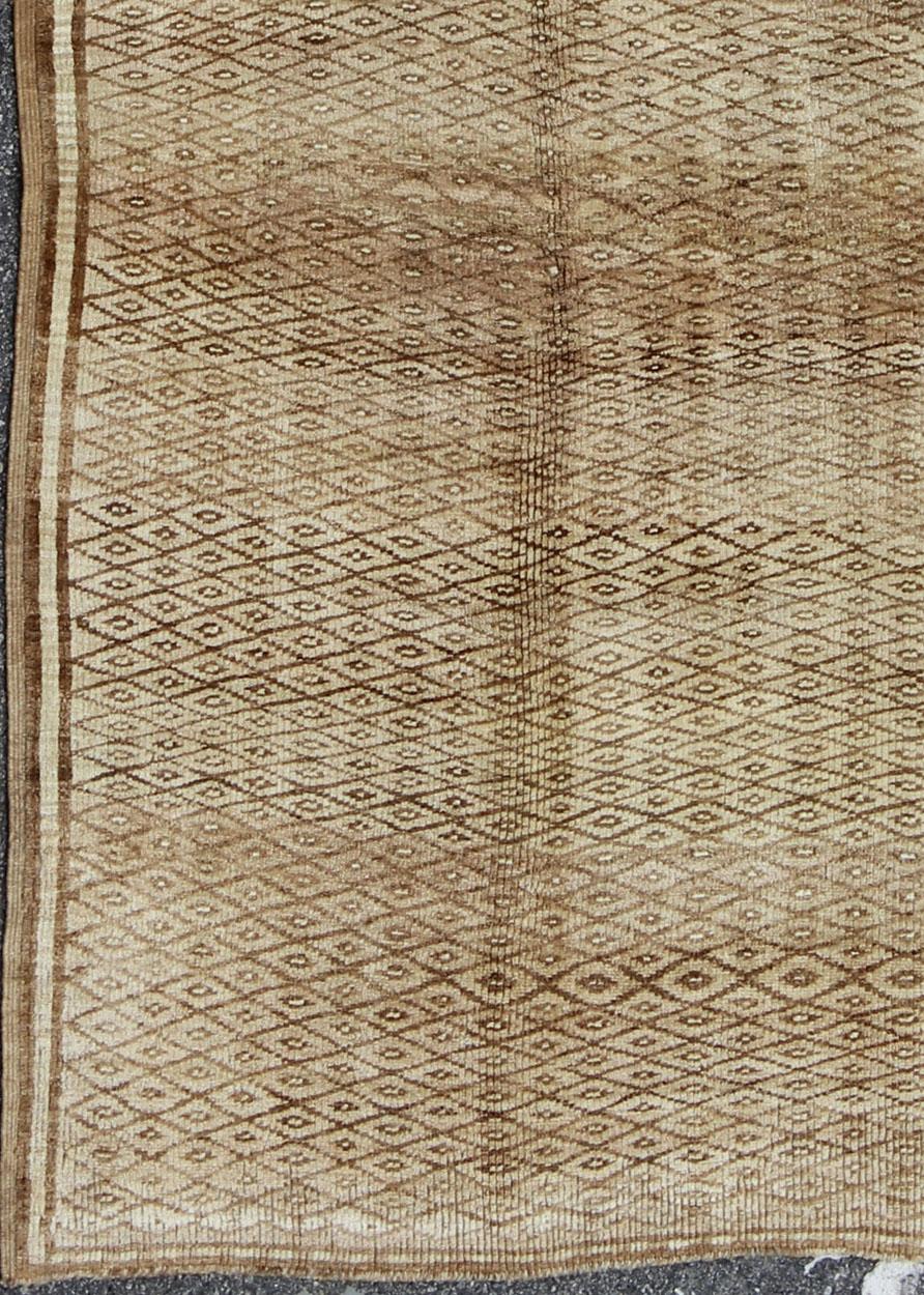 Türkischer Oushak Konya-Teppich mit braunem und braunem Rautenmuster, elfenbeinfarbene Akzente.
Dieser schöne alte Konya-Teppich aus der Türkei der 1950er Jahre weist ein kompliziertes Rautenmuster auf. Die sanften Braun- und Mitteltöne verleihen
