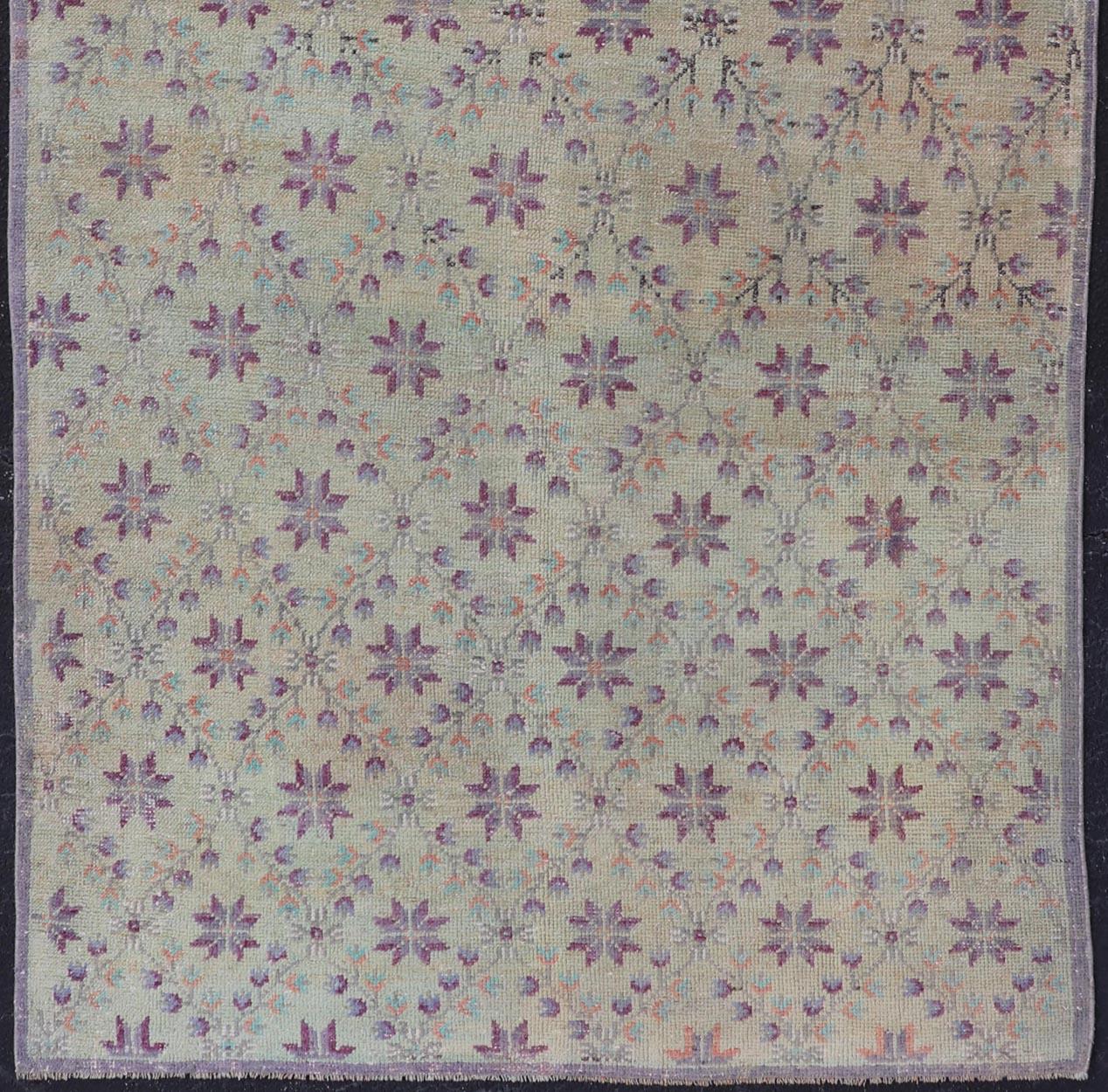 Measures: 4'4 x 9'5 

This Turkish Oushak rug features common composition for the region. This piece, heavily inspired by Tulu rugs from the Konya region, features a lattice design with purple blossoms within the design. The palette for this piece