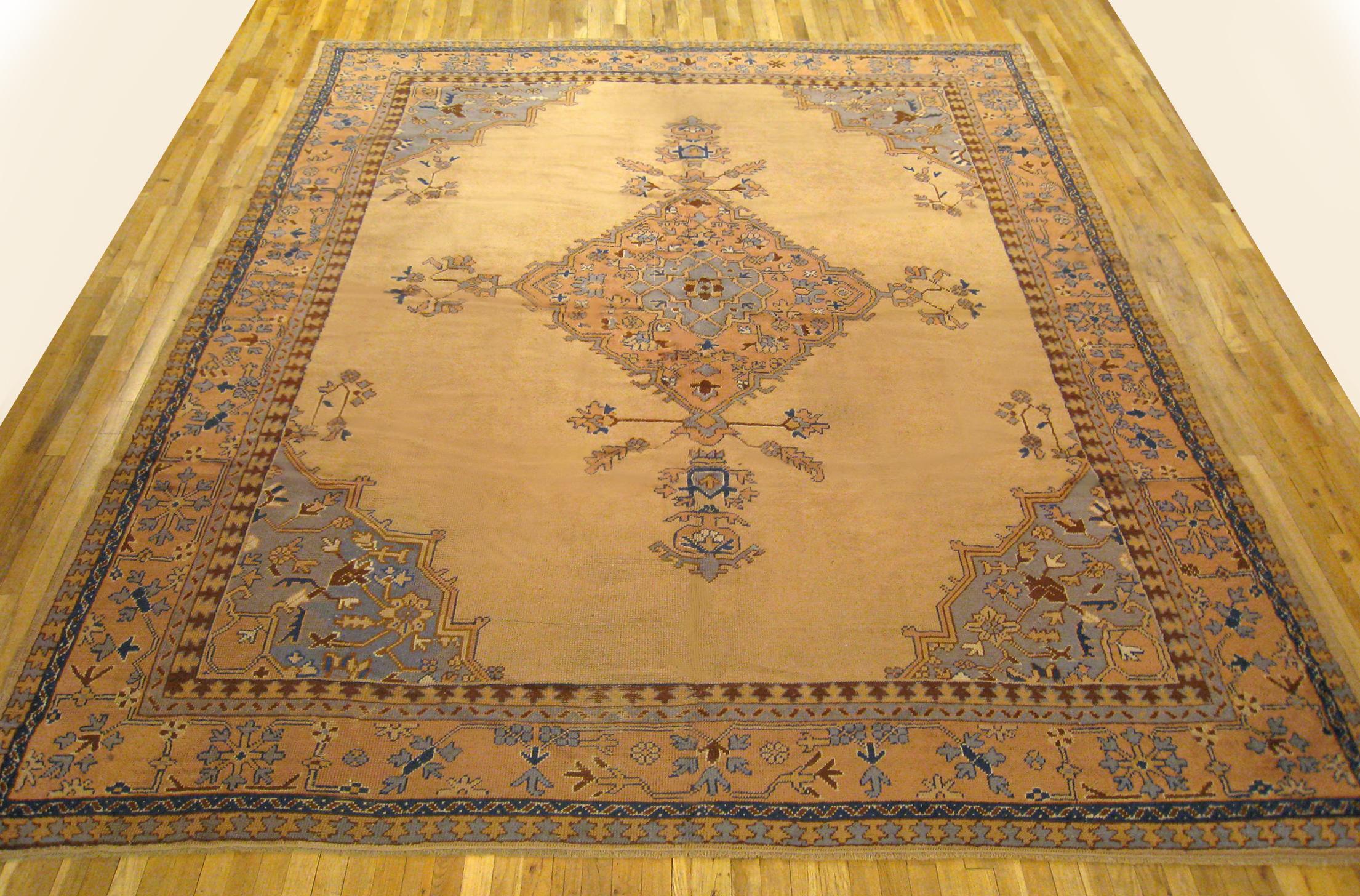 Vintage Turkish Oushak oriental rug, size 12'5 H x 10'0 W, circa 1930.  This hand-knotted semi-antique wool Turkish carpet features soft earth tones throughout, with a medallion design on an otherwise open central field.  This nicely balanced piece