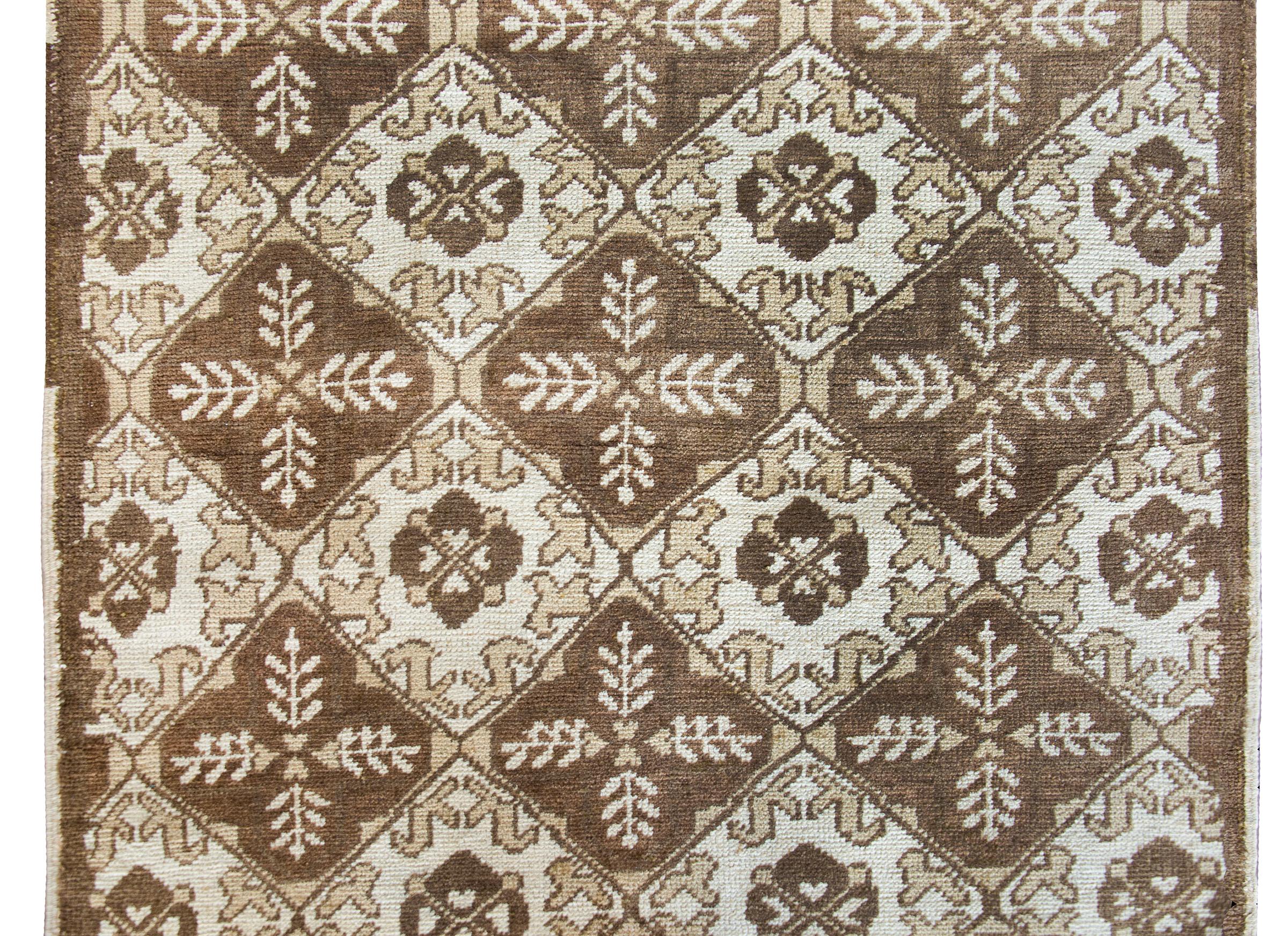 A wonderful mid-20th century Turkish Oushak rug with an all-over repeated stylized floral and leaf pattern woven in varying shades of brown, beige, and tan.