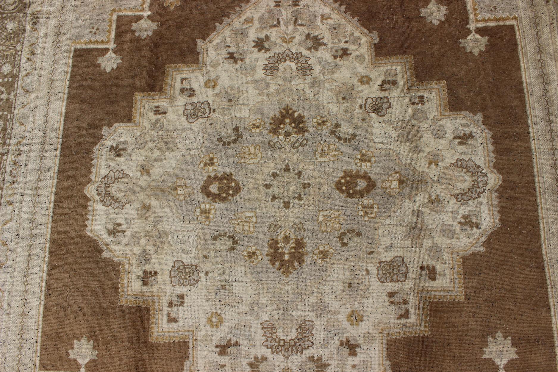 Wool Vintage Turkish Oushak Rug in Brown Background and Neutral Colors For Sale