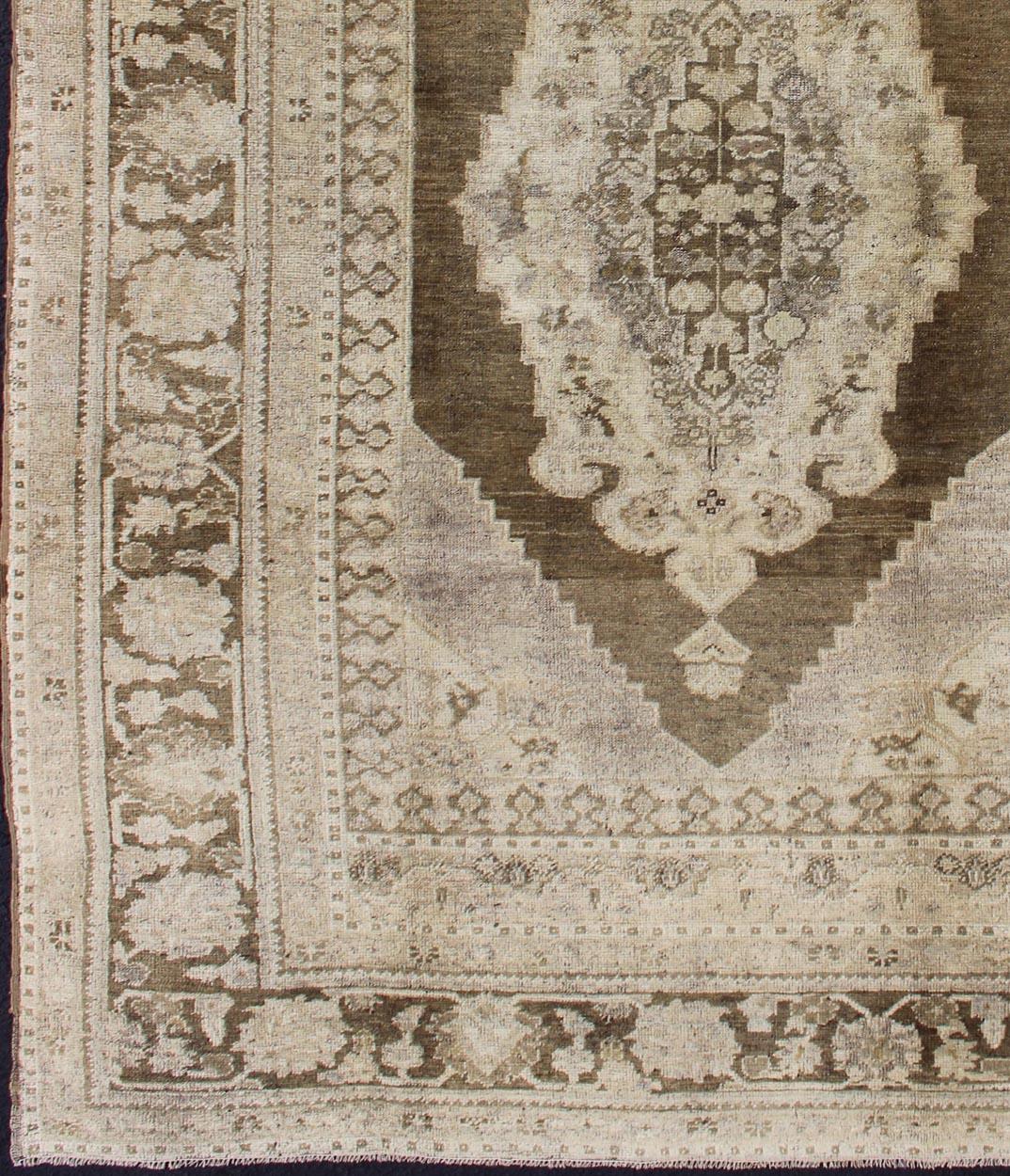 Vintage Turkish Oushak Rug in Brown/Green, Taupe and Neutral Colors.
This Turkish Oushak is set on taupe background with a medium Greenish brown colors. The border displays flower pattern with connecting vines. 
Measures: 5'8 x 8'3.