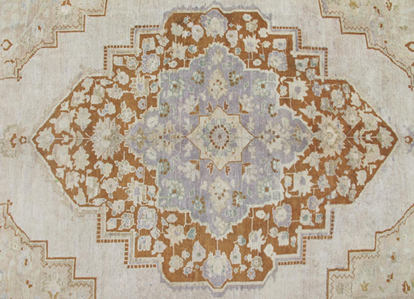 Measures: 6'10 x 10'5

This softly colored Oushak carpet rests beautifully upon a field of elegant light taupe. A large medallion of lavender/gray and saddle brown takes center stage and is well balanced by four prominent organic corner motifs