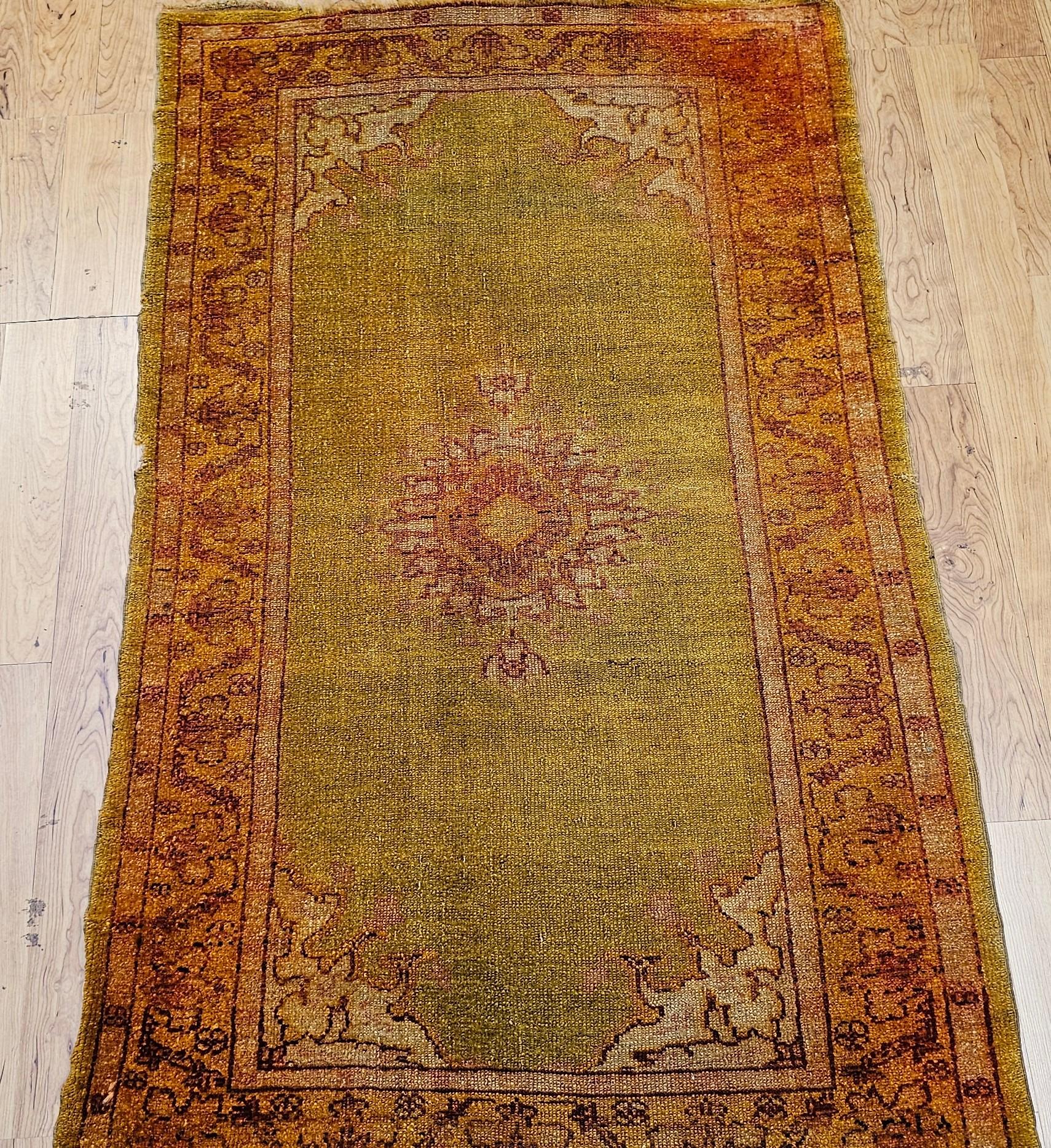 Un raro tappeto Oushak turco della fine del XIX secolo con un campo abrasivo color chartreuse con un piccolo medaglione e un bordo giallo chiaro accentuato da viti rosso ruggine. Questo elegante pezzo di Anatolia incarna un'arte senza tempo e