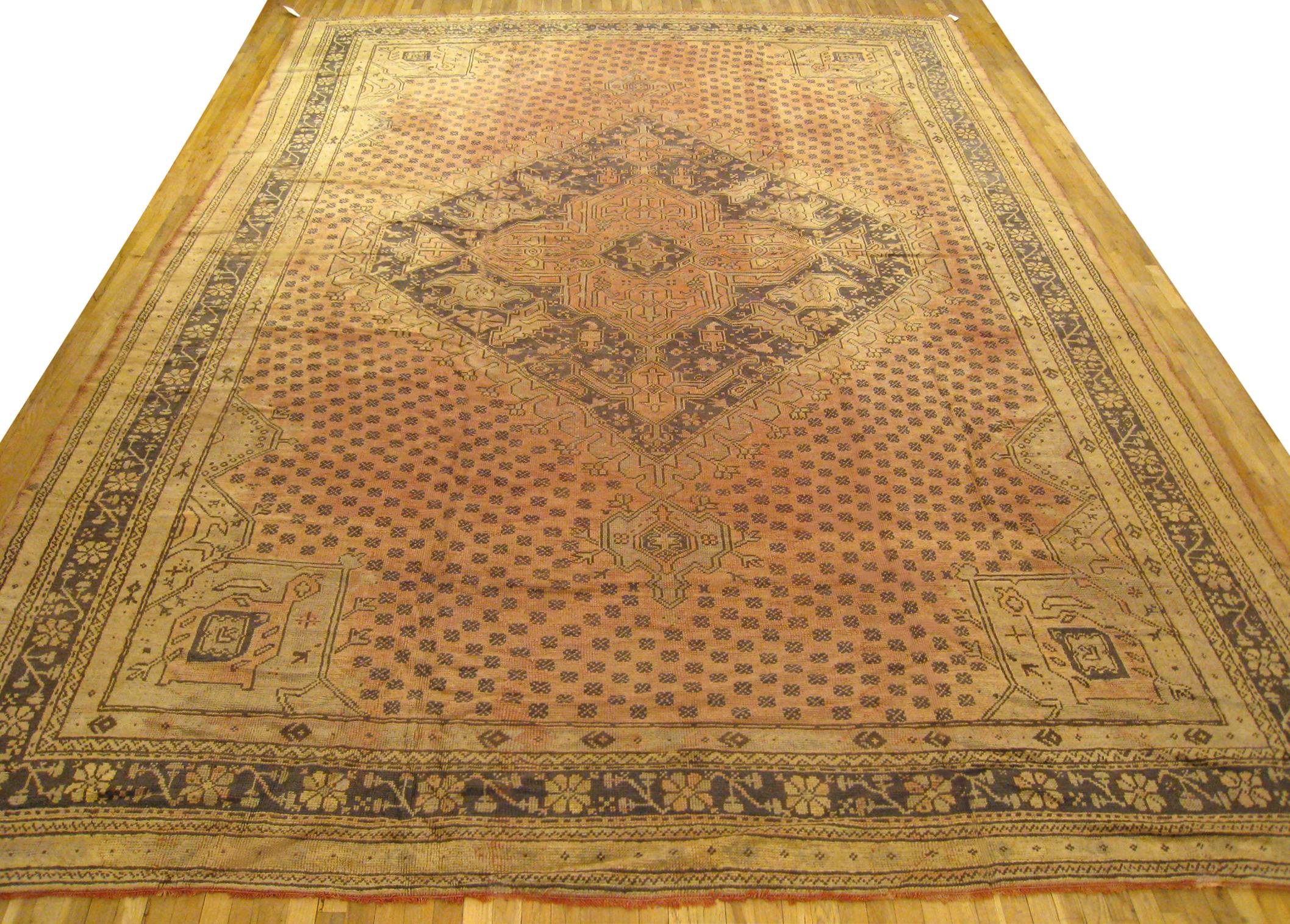Vintage Turkish Oushak rug, size 17'0 H x 12'0 W, circa 1930.  This hand-knotted semi-antique wool Turkish carpet features soft earth tones throughout, with a medallion design on a central field covered with small geometric motifs.  This nicely