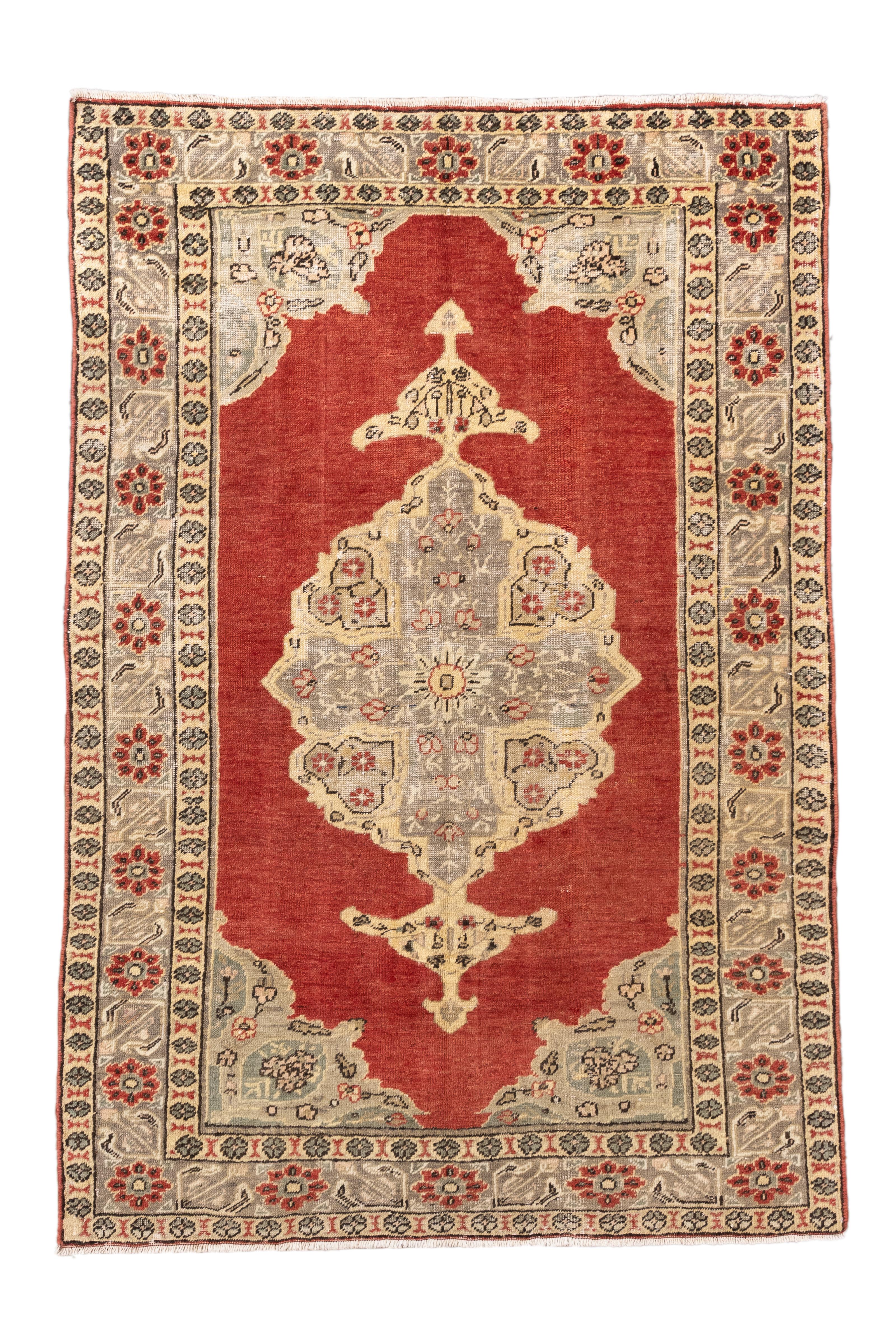 Questo tappeto Oushak vintage annodato a mano nella Turchia occidentale presenta un campo rosso cremisi in contrasto con un delicato medaglione e angoli in celadon e oro pallido. I motivi floreali dei bordi e un grazioso disegno a medaglione