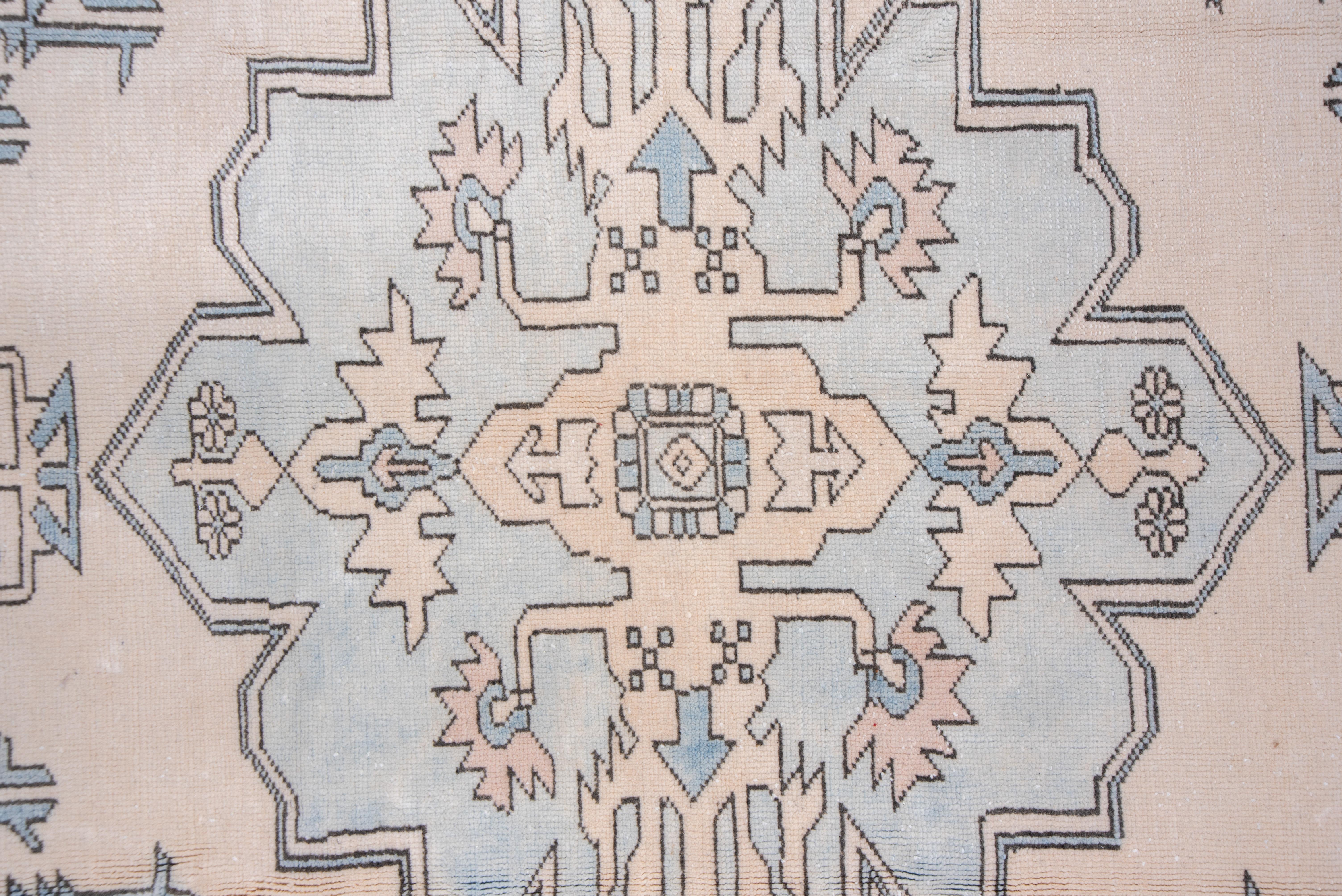 The sky blue field grounds a sandy-straw panel internally edged by hooks and flowers. It centers a palest grey irregular 12-lobe geometric medallion. The buff main border owes something to the Persian turtle pattern.