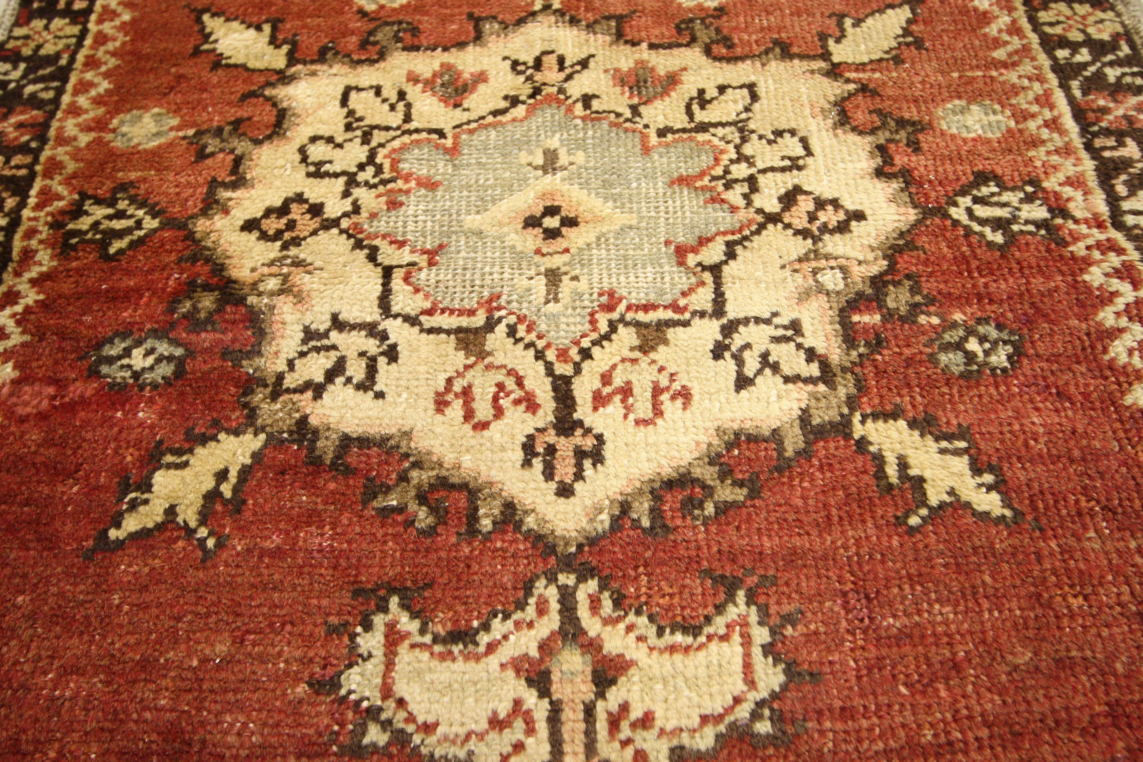 51398, a vintage Oushak rug runner. This hand-knotted wool vintage Turkish Oushak runner features three central medallions outlined in stark contrasting black interspersed with three petaled lotus symbols on an abrashed red field. The spandrels echo