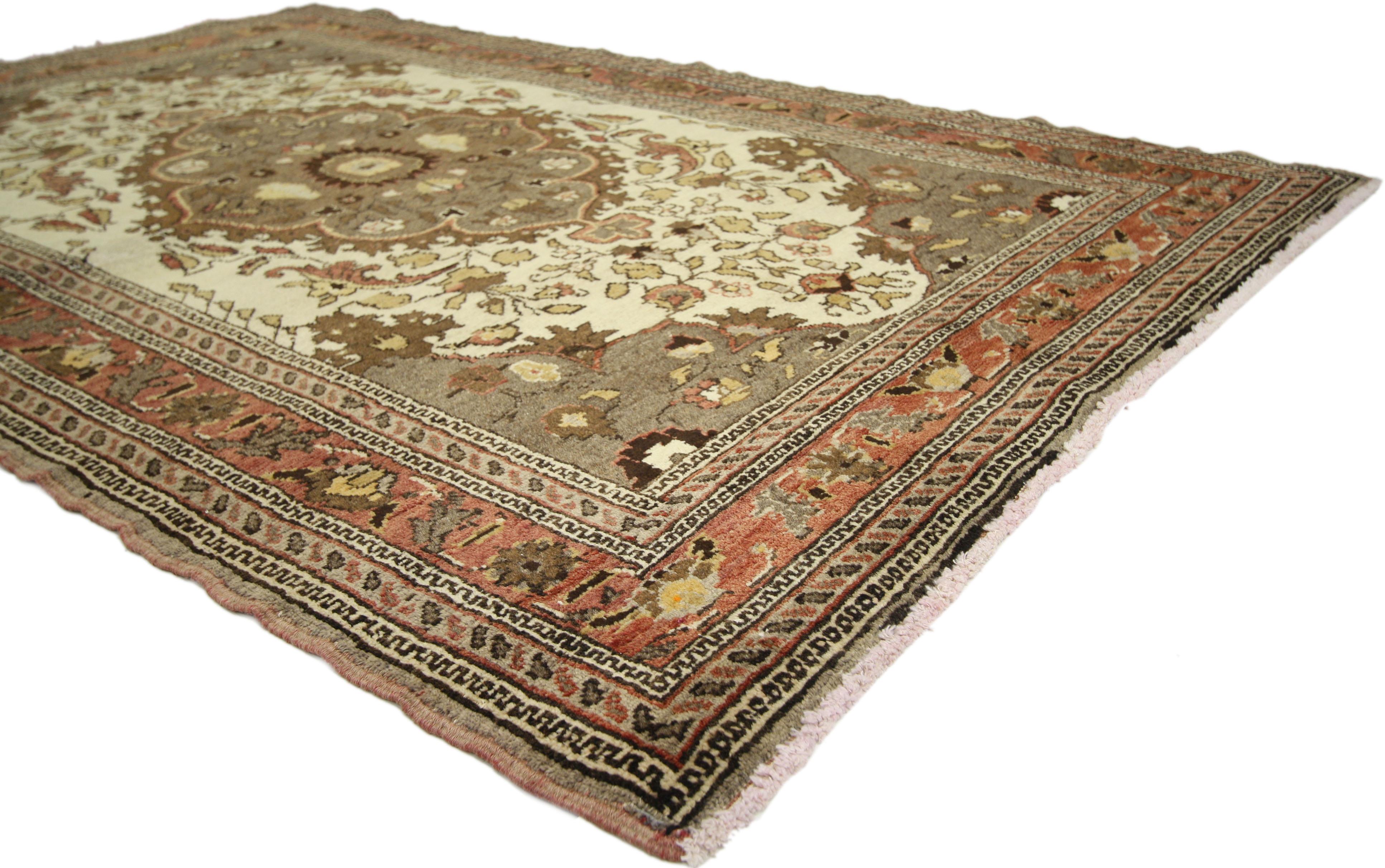 50094, a vintage Turkish Oushak rug with central medallion design. This opulent Turkish Oushak rug features a central medallion of taupe with an overlay of arabesque vines and lush primroses. Spandrels echo the hues of the medallion and contrast