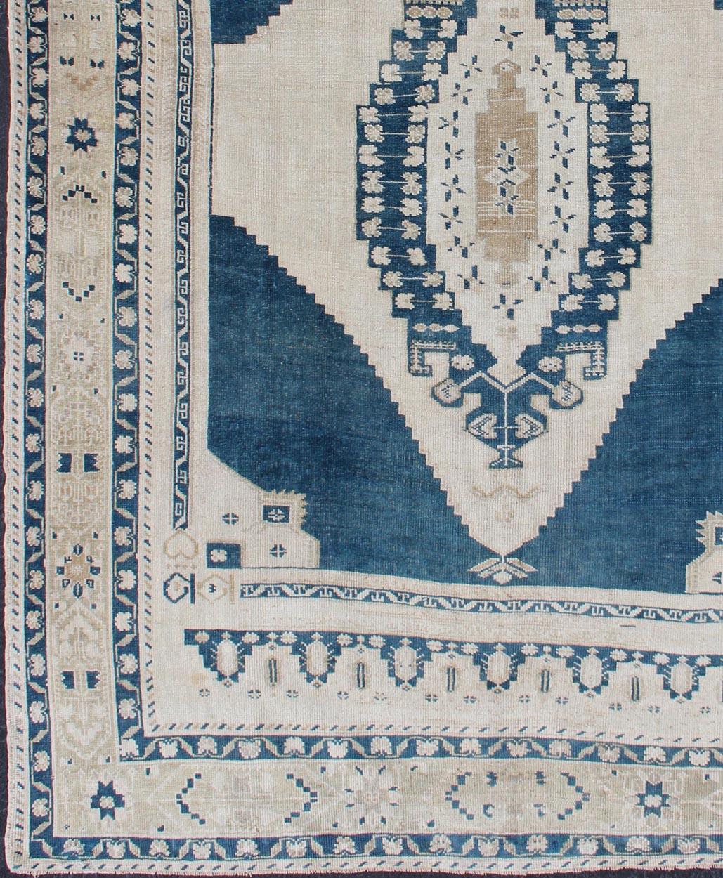 Faded vintage Turkish Oushak rug with Central Medallion in cream and blue, rug tu-mtu-4929, country of origin / type: Turkey / Oushak, circa 1940

This sublime and enchanting vintage rug, a gorgeous Oushak rug made in Turkey during the mid-20th