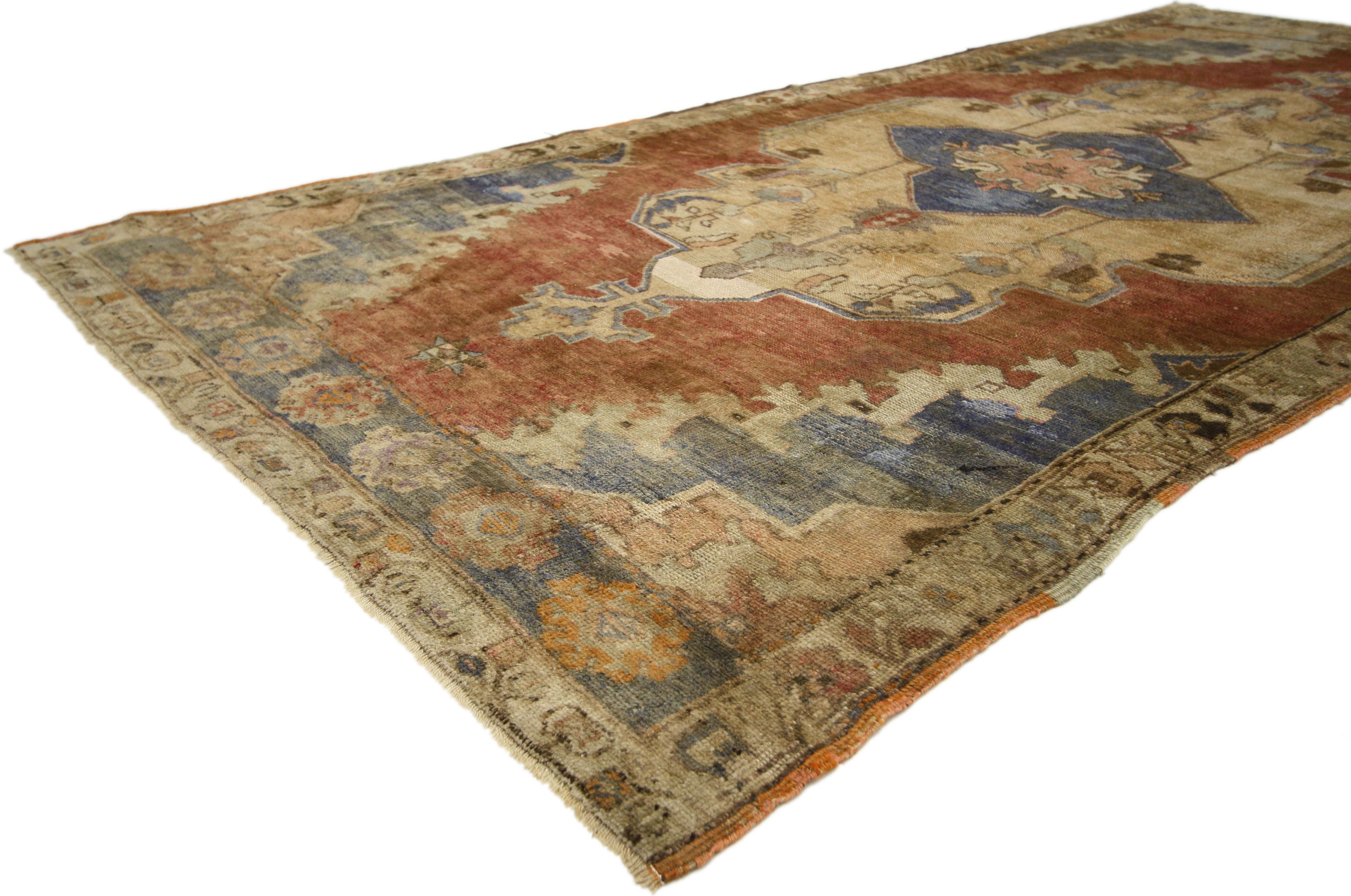 50312, vintage Turkish Oushak rug with craftsman French Provincial style. This hand knotted wool vintage Turkish Oushak rug features a large scalloped center medallion with palmette anchor pendants floating on an abrashed terra cotta field. The