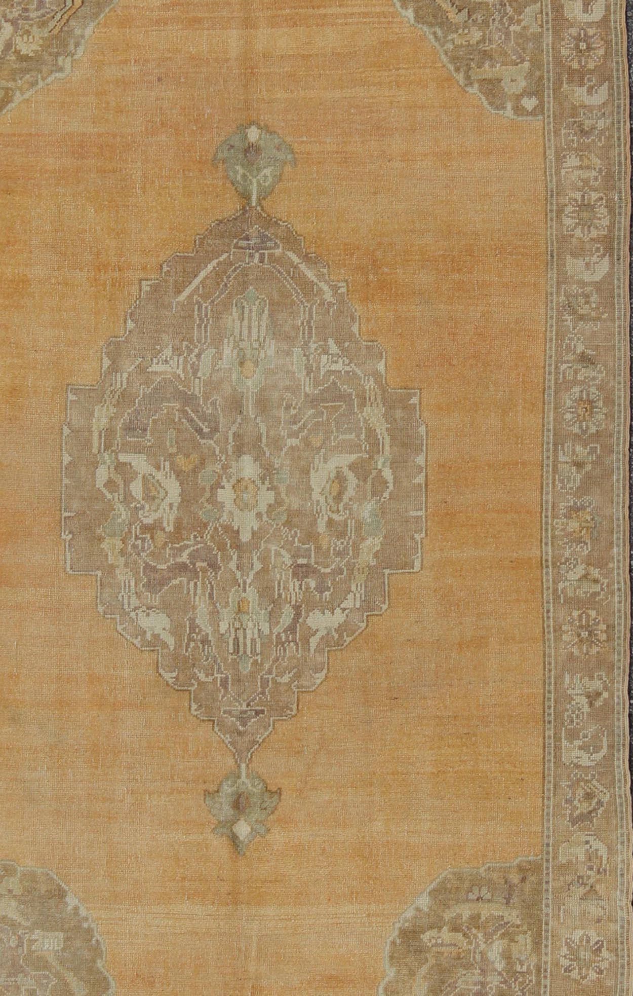 Vieux tapis turc Oushak noué à la main avec médaillon floral orné en orange délavé, camel et brun clair, Keivan Woven Arts / tapis en-4544, pays d'origine / type : Turquie / Oushak, vers le milieu du 20e siècle

Ce tapis turc Oushak vintage