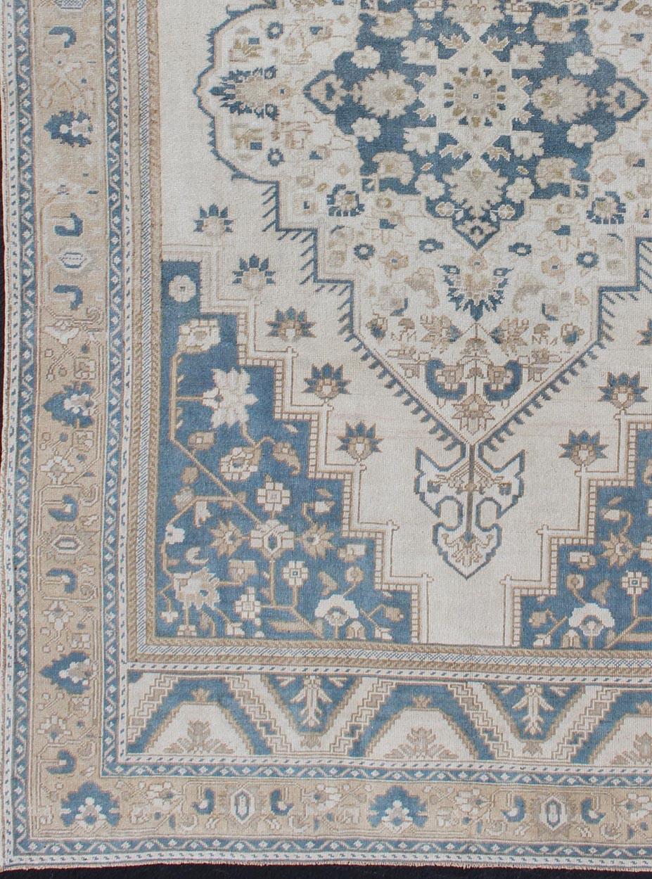 Taupe, cream and blue Oushak rug vintage from Turkey with medallion design of etched motifs, rug tu-mtu-4930, country of origin / type: Turkey / Oushak, circa 1940.

This striking vintage Turkish Oushak rug bears a blue-colored body that is