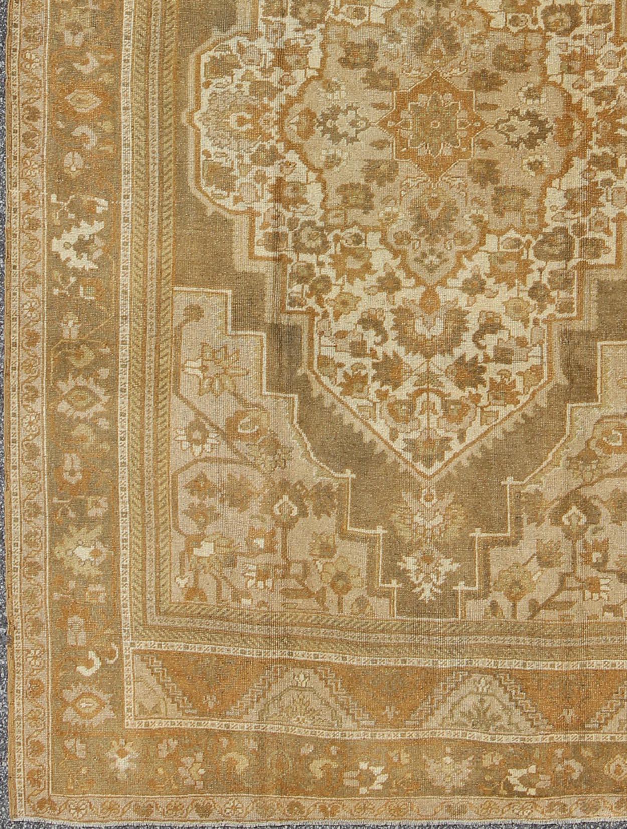 Measures 6'5 x 9'7 

This vintage Turkish Oushak carpet, (circa mid-20th century) features a floral central medallion design, as well as patterns of smaller tribal elements in the four cornices, and in the surrounding borders. Colors include