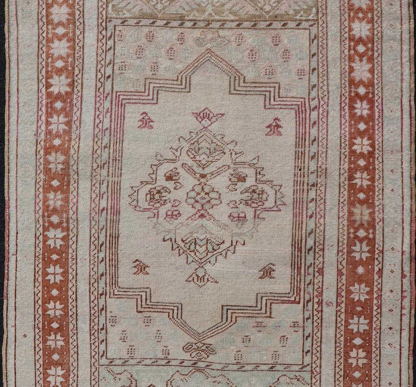 Measures: 3'4 x 5'4 

Hand-knotted in Turkey during the 1940's, this vintage Oushak features a great medallion and layer cornices. The field is lined in a brown-red color, with light blue and cream blended for a soft background, similar to the