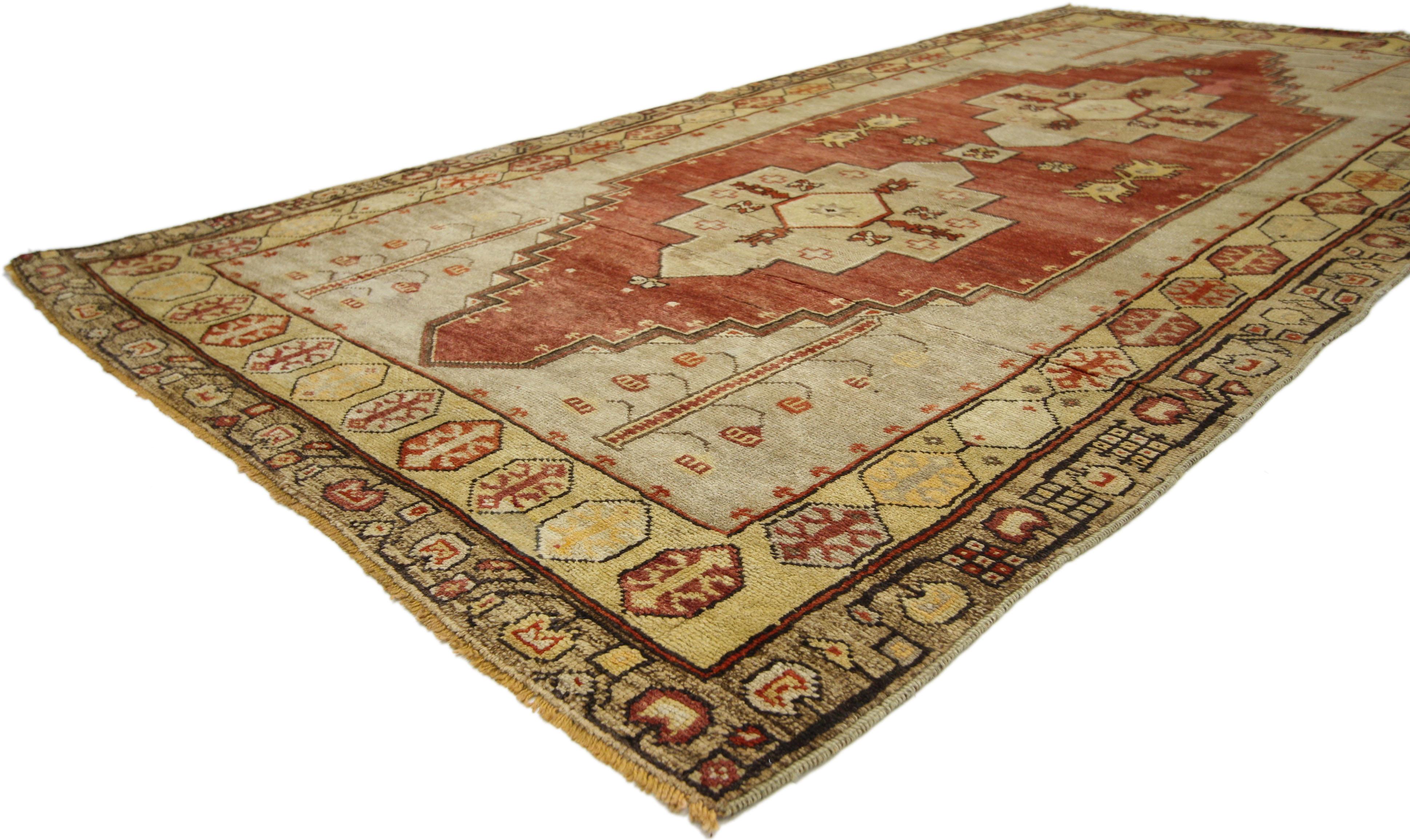 50643, vintage Turkish Oushak rug with Mid-Century Modern Tribal style. This hand knotted wool vintage Turkish Oushak rug features two connected stepped medallions filled with rosettes, crosses, and eight-point stars. The double medallion is dotted