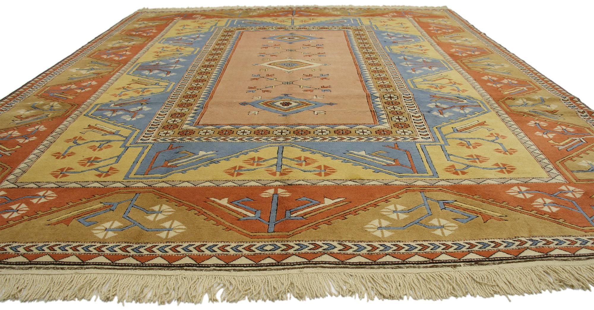 77132, vintage Turkish Oushak rug. This hand-knotted wool vintage Turkish Oushak rug features rectangular medallion filled with three diamond motifs and cross-like sprigs surrounded by a rosette border in cut out field of blue and yellow.