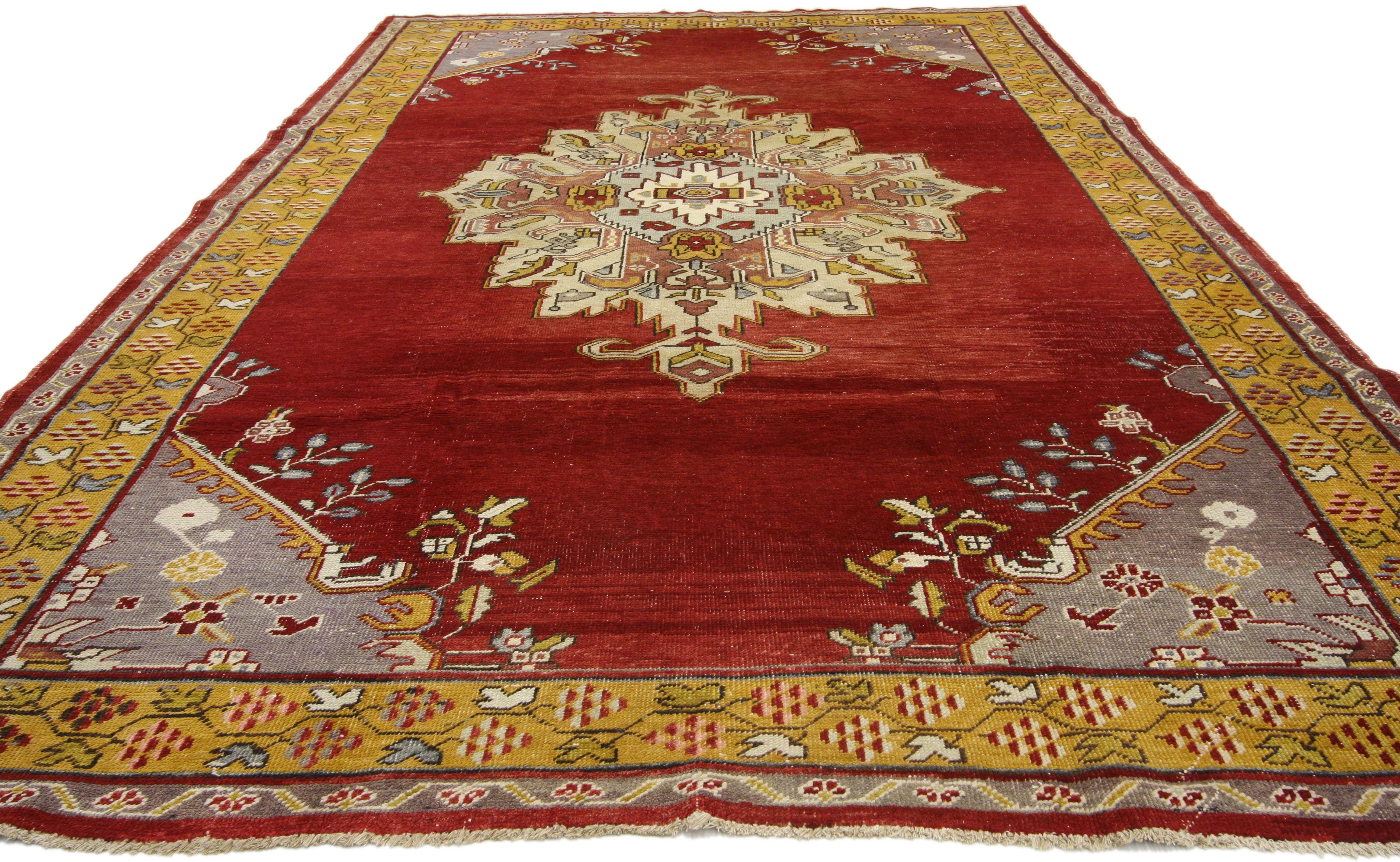 73774 Vintage Turkish Oushak rug with Regency style and vibrant colors. This hand knotted wool vintage Turkish Oushak rug features a large lobed central medallion with hands-on-hips pendants floating on an abrashed ruby red field. Palmettes, open