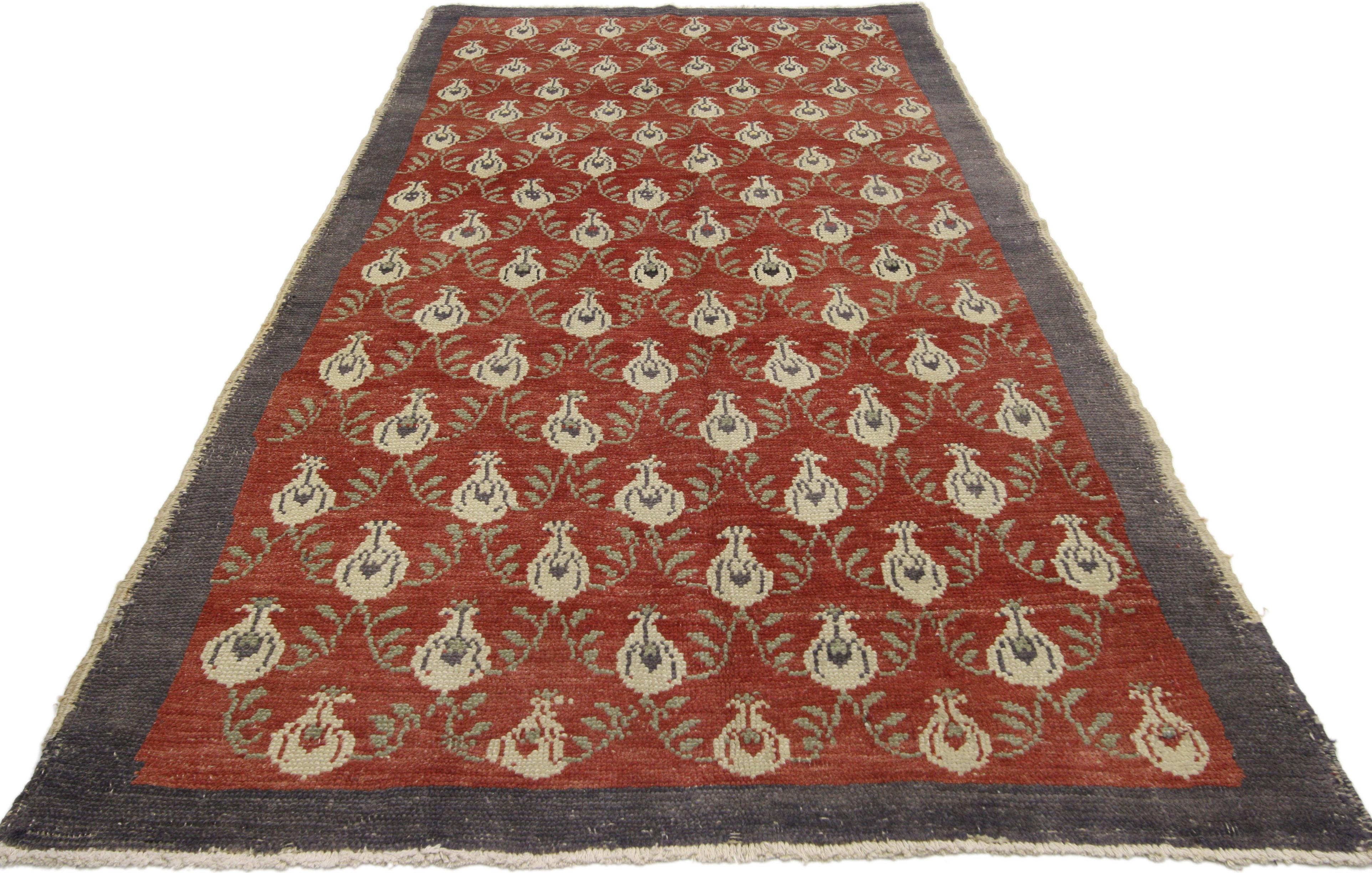 51309, vintage Turkish Oushak rug with Romantic Craftsman style. This hand knotted wool vintage Turkish Oushak rug features a floral lattice patter of budding tulips spread across an abrashed brick red field. Curving leafy vines connect the