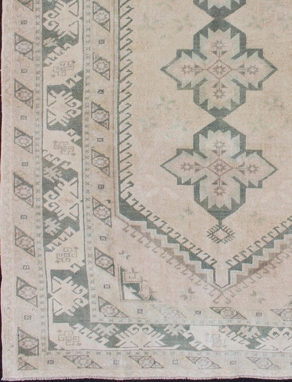 Maße: 4'6 x 7'0 
Vintage Türkischer Oushak Teppich mit weichem Beige Feld und verblasstem Grün 4'6 x 7'0. Keivan Woven Arts / Teppich / TU-MTU-4817, Herkunftsland / Typ: Türkei / Oushak, um 1940.

Dieser türkische Oushak-Teppich im Vintage-Stil