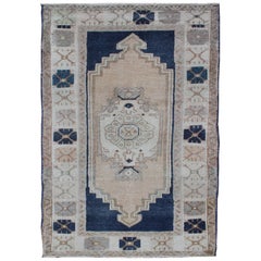 Tapis turc vintage Oushak avec médaillon stylisé en bleu nuit et crème