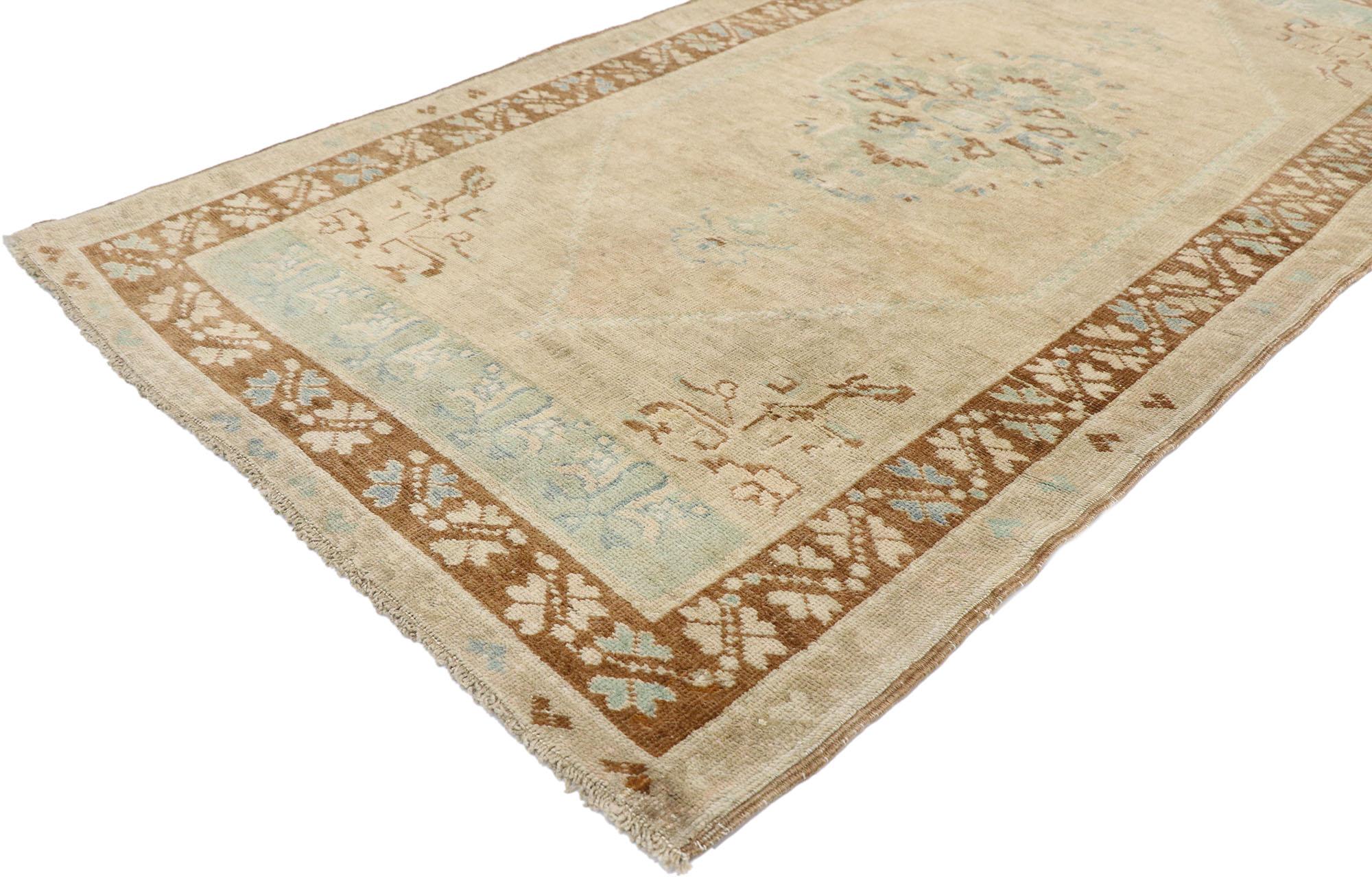 53519 Vintage Turkish Oushak Rug, 03'07 x 06'09. This hand-knotted wool vintage Turkish Oushak rug exudes timeless allure, drawing the eye with its neutral earth-tone hues and nostalgic charm. The abrashed tan-colored field sets the stage for a