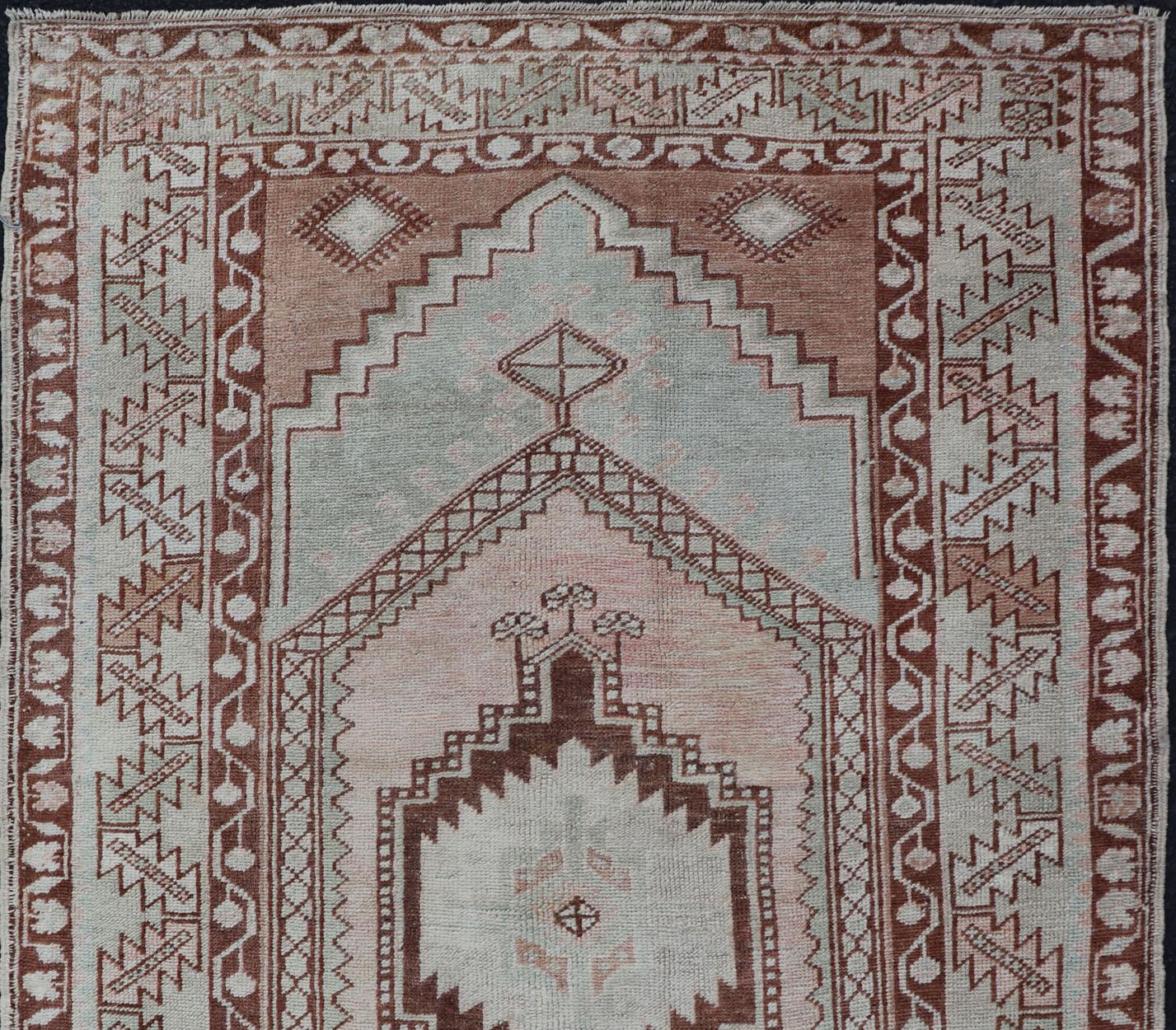 Muted color antique Turkish Oushak carpet with traditional floral medallion design, rug EN-178029, country of origin / type: Turkey / Oushak, circa 1940

This striking Turkish Oushak rug bears a light blue colored along with brown, blush, salmon