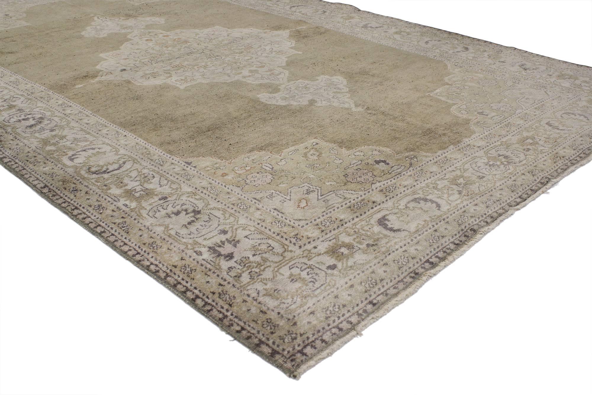 52071, vintage Turkish Oushak rug with traditional style, earth tone colors. This hand-knotted wool vintage Turkish Oushak rug features an elaborate grand center medallion with adjoining palmettes in an open abrashed field. A deep, layered border