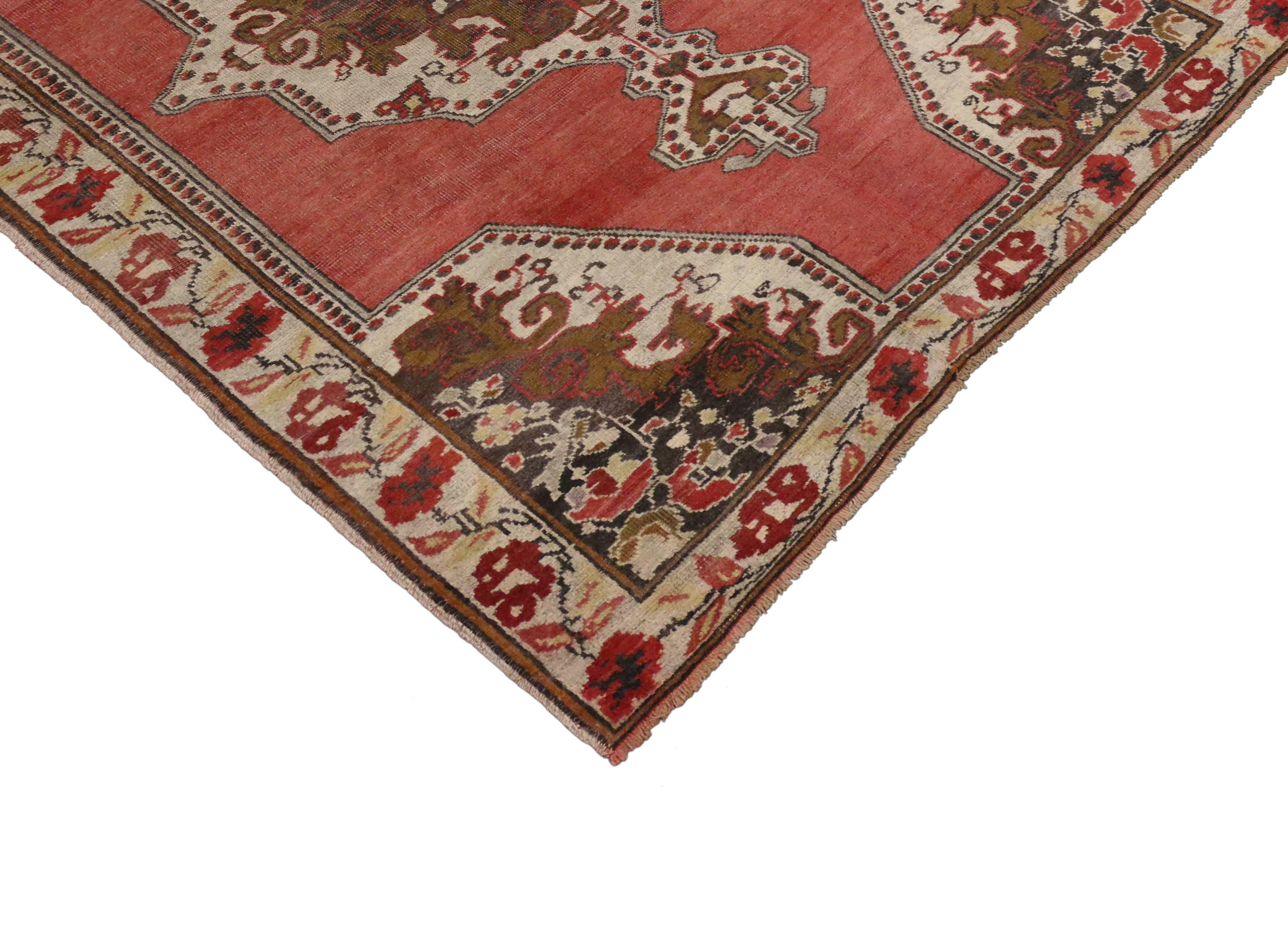 73916, vintage Turkish Oushak rug with traditional style. This hand-knotted wool vintage Turkish Oushak rug features an elaborate central medallion on an abrashed red field in a traditional style. It is framed by sharply geometric corner spandrels