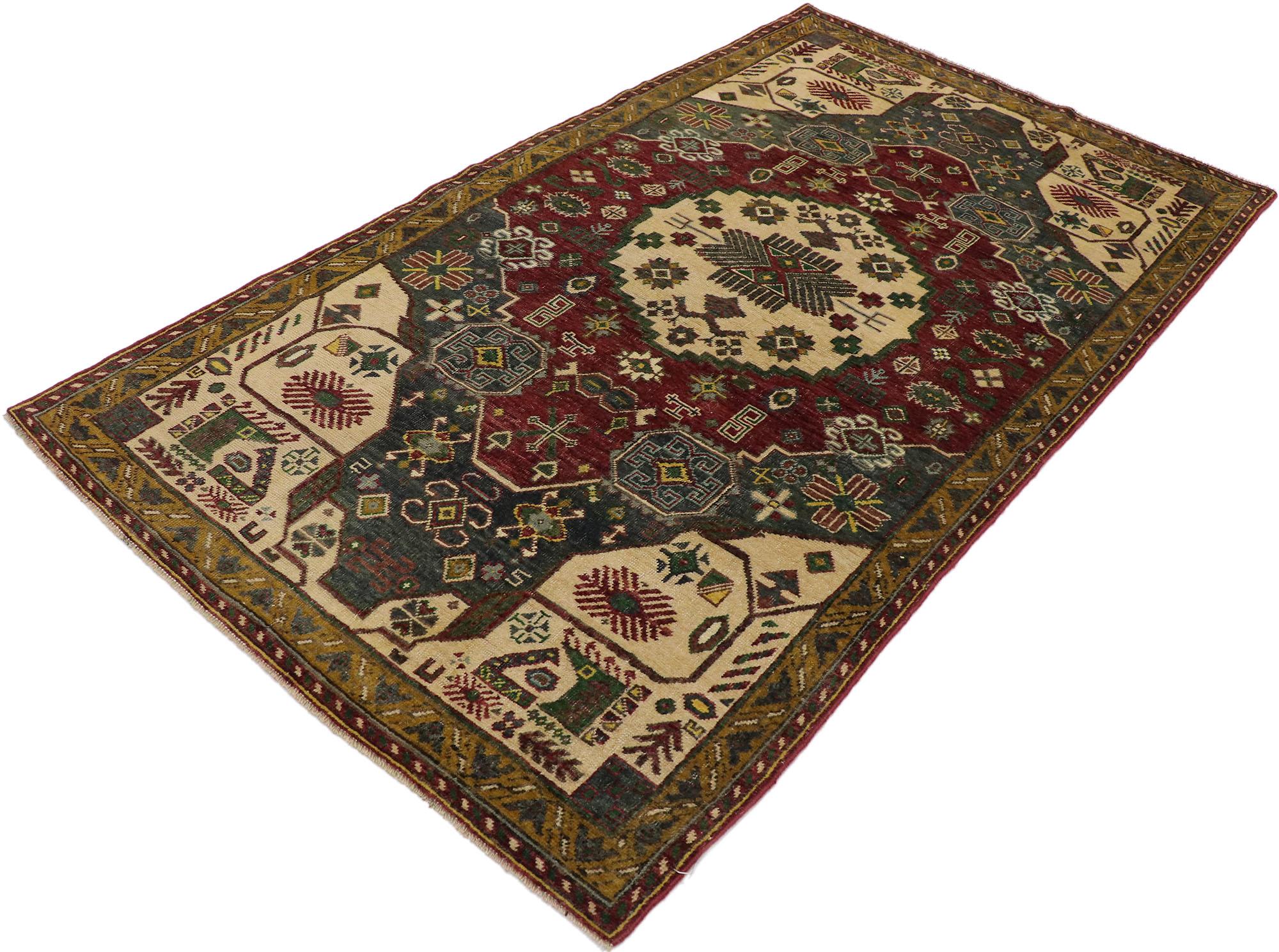 53177, vintage Turkish Oushak rug with Tribal style. Embodying tribal style and charm with saturated colors, this hand knotted wool vintage Turkish Oushak rug is a captivating vision of woven beauty. The abrashed field features a round central