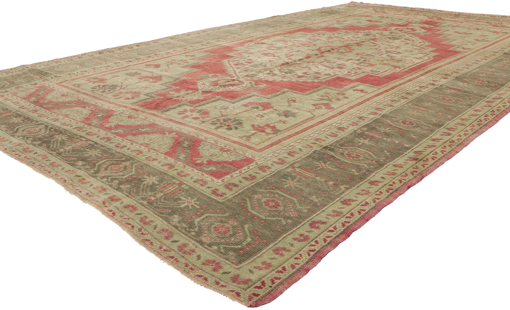 51367 vintage Turkish Oushak rug with Tudor style. This hand knotted wool vintage Turkish Oushak rug features an oversized stepped hexagonal medallion with blooming palmette pendants floating in the center of an abrashed brick red field. Gorgeous