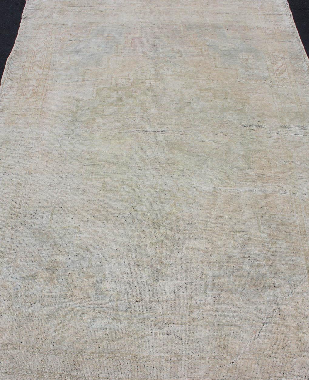 Mid-20th Century Vintage Turkish Oushak Rug with Understated Design and Muted Tones For Sale