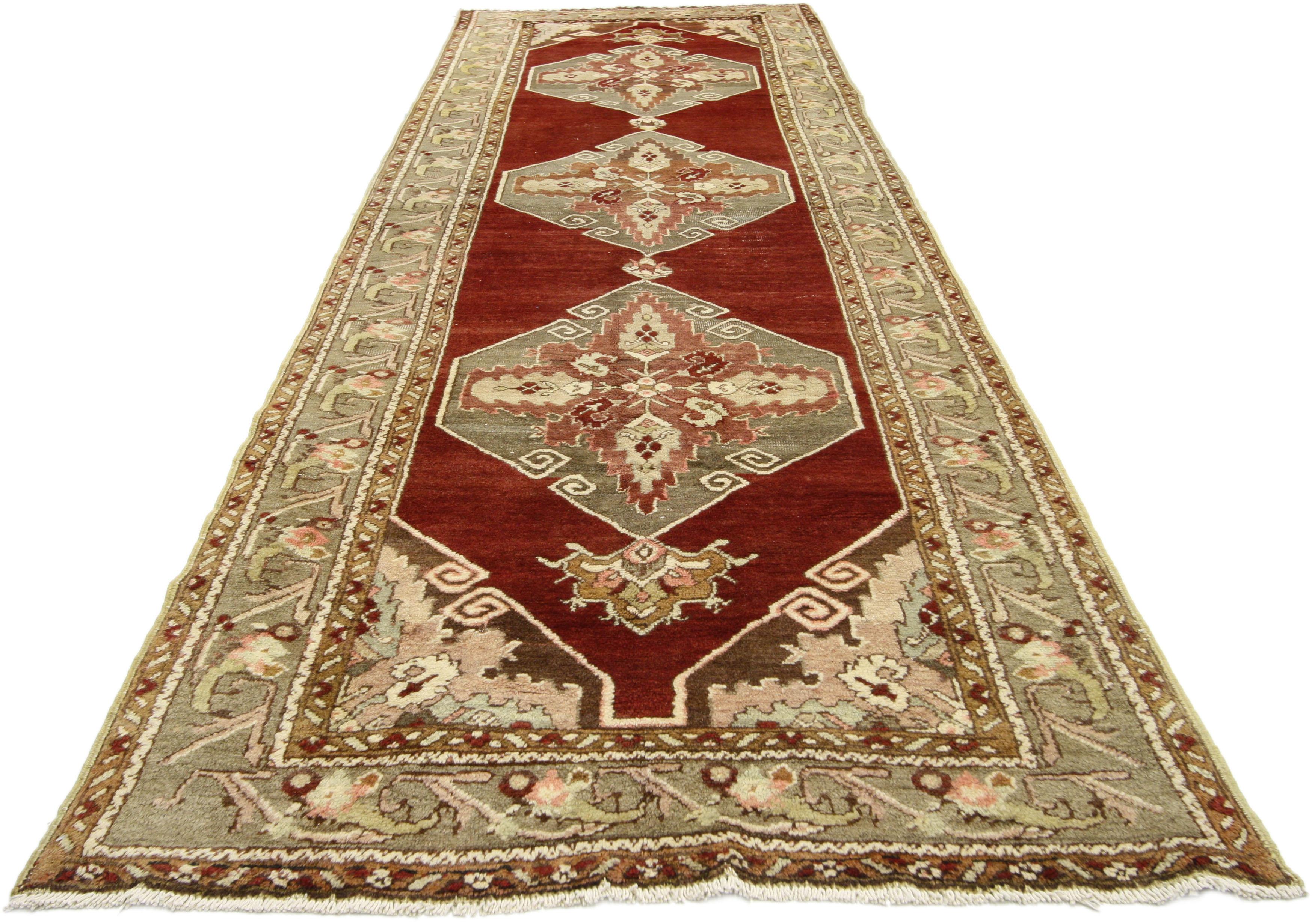 52402, vintage Turkish Oushak runner, Jacobean style hallway runner. This hand-knotted wool vintage Turkish Oushak runner features three connected hexagonal medallions capped with palmette pendants spread across an abrashed scarlet red field. Each