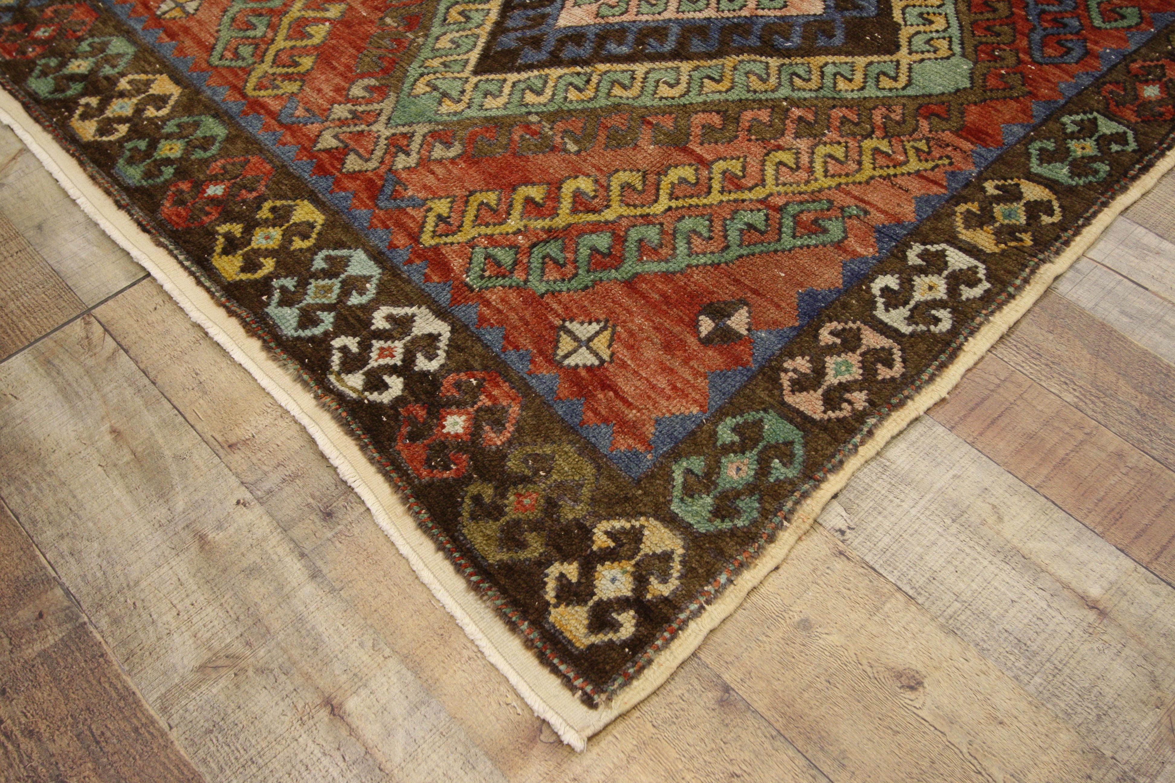 52396, vintage Turkish Oushak runner, tribal style hallway runner. This hand knotted wool vintage Turkish Oushak runner features three lozenge medallions with latch hook edges and steep latch hooked ziggurats protruding towards the centre. The main