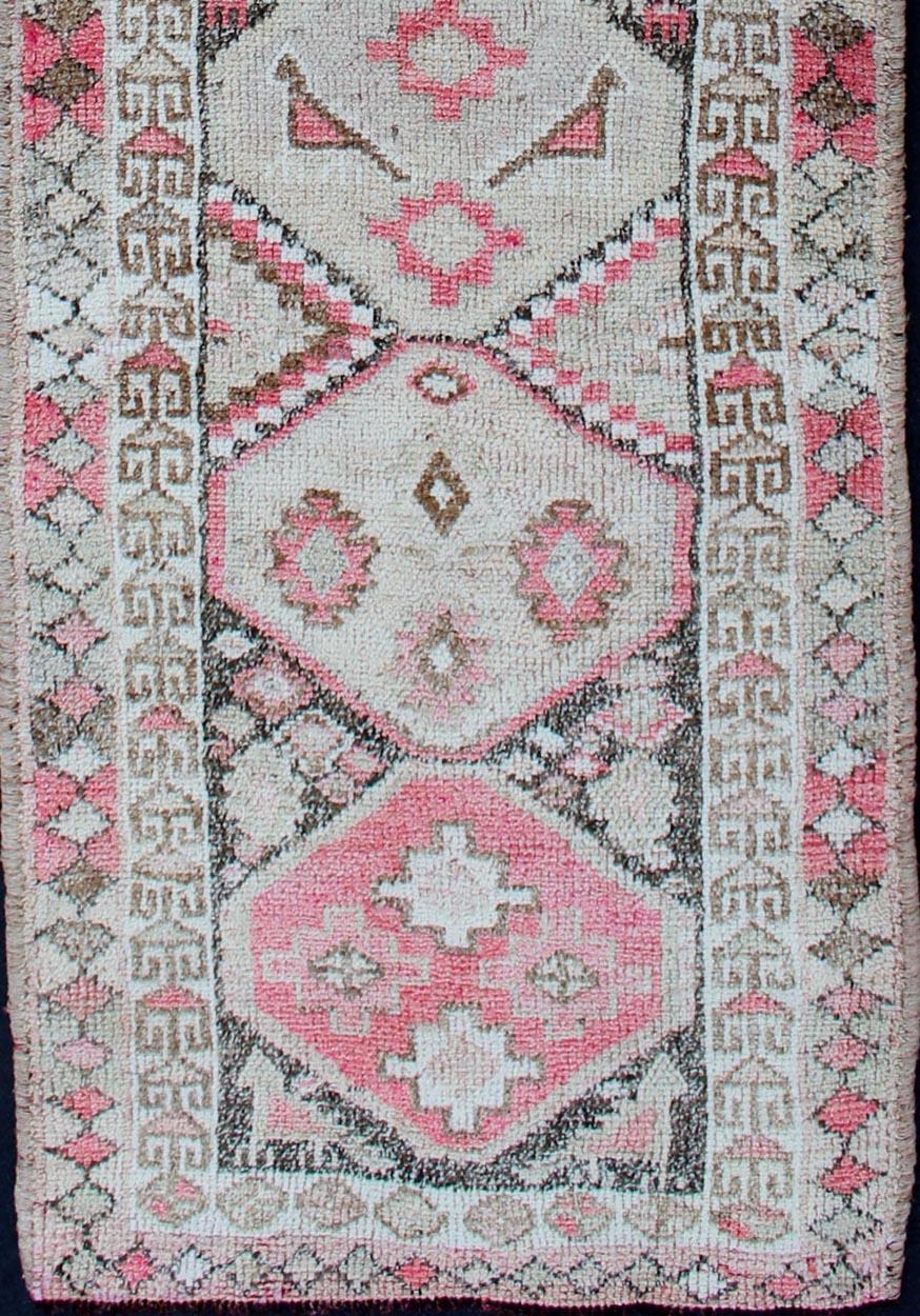 Vintage Oushak runner from Turkey with Vertical Medallion design in multi-colors, charcoal, pink, red, and faint green. Rug en-165340, country of origin / type: Turkey / Oushak, circa 1950s.

This beautiful vintage Oushak runner from 1950s Turkey