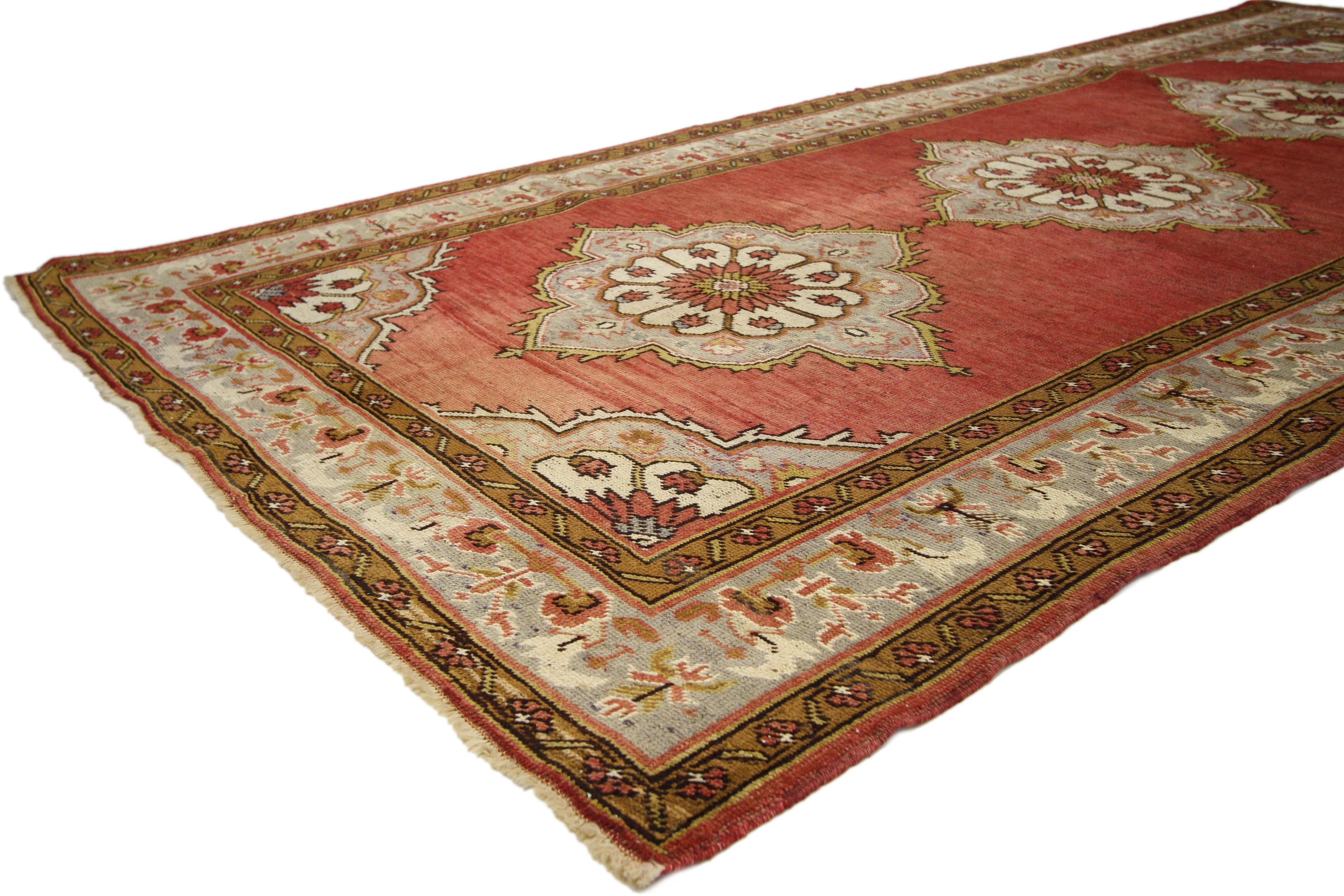 73753, vintage Turkish Oushak Gallery rug, Wide Hallway Runner with Jacobean Tudor style. Impressive in style and impeccably woven, this vintage Turkish Oushak rug with modern elegance features three ornate medallions in an open Abrash red field