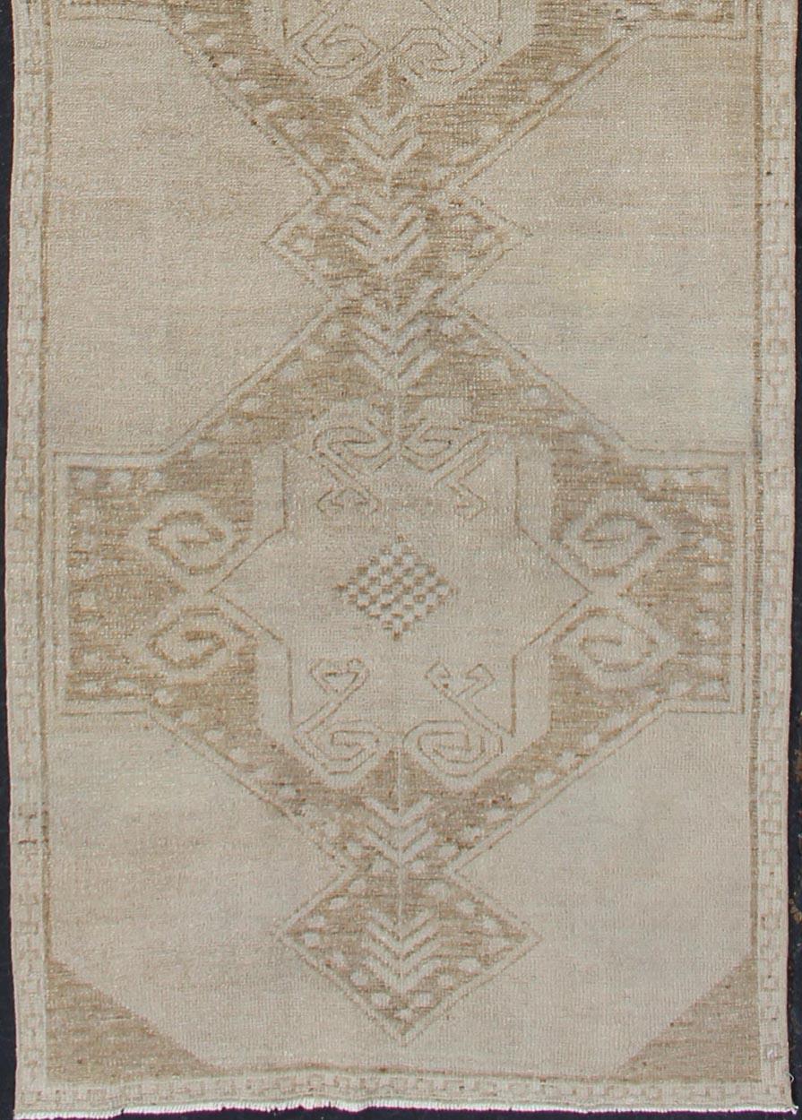 Vintage Medallion Turkish Oushak runner in tan with brown and taupe. Keivan Woven Arts / rug TU-ALK-3576, country of origin / type: Turkey / Oushak, circa 1940.

This unique vintage Turkish Oushak runner features an tribal medallions of subdued
