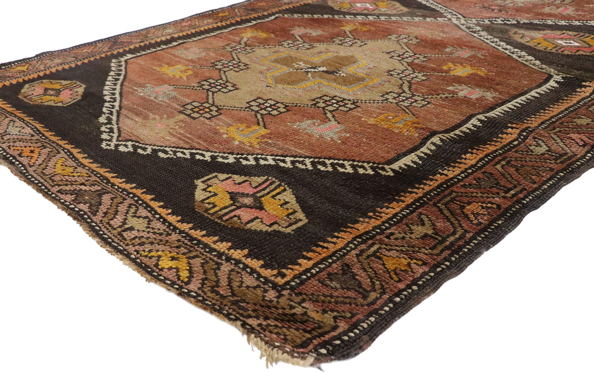 Hand-knotted wool vintage Turkish Oushak runner with Mid-Century Modern style featuring three large stacked hexagon medallions and tribal motifs in an open brown field with rich waves of abrash. With its Mid-Century Modern style and captivating