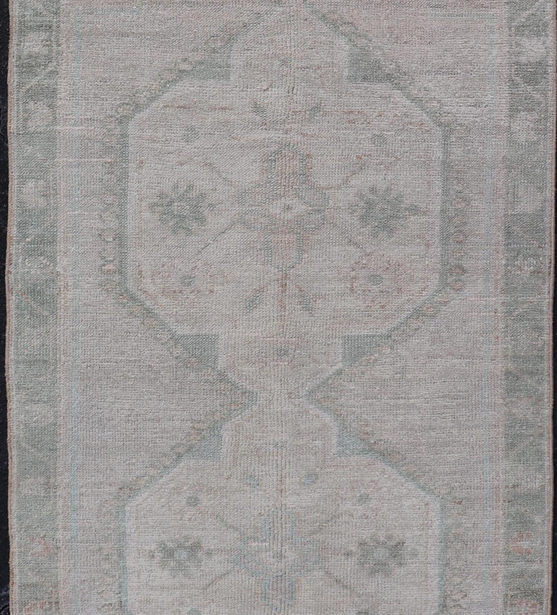 20th Century Vintage Turkish Oushak Runner with Subdued Geometric Medallions in Light Tones For Sale