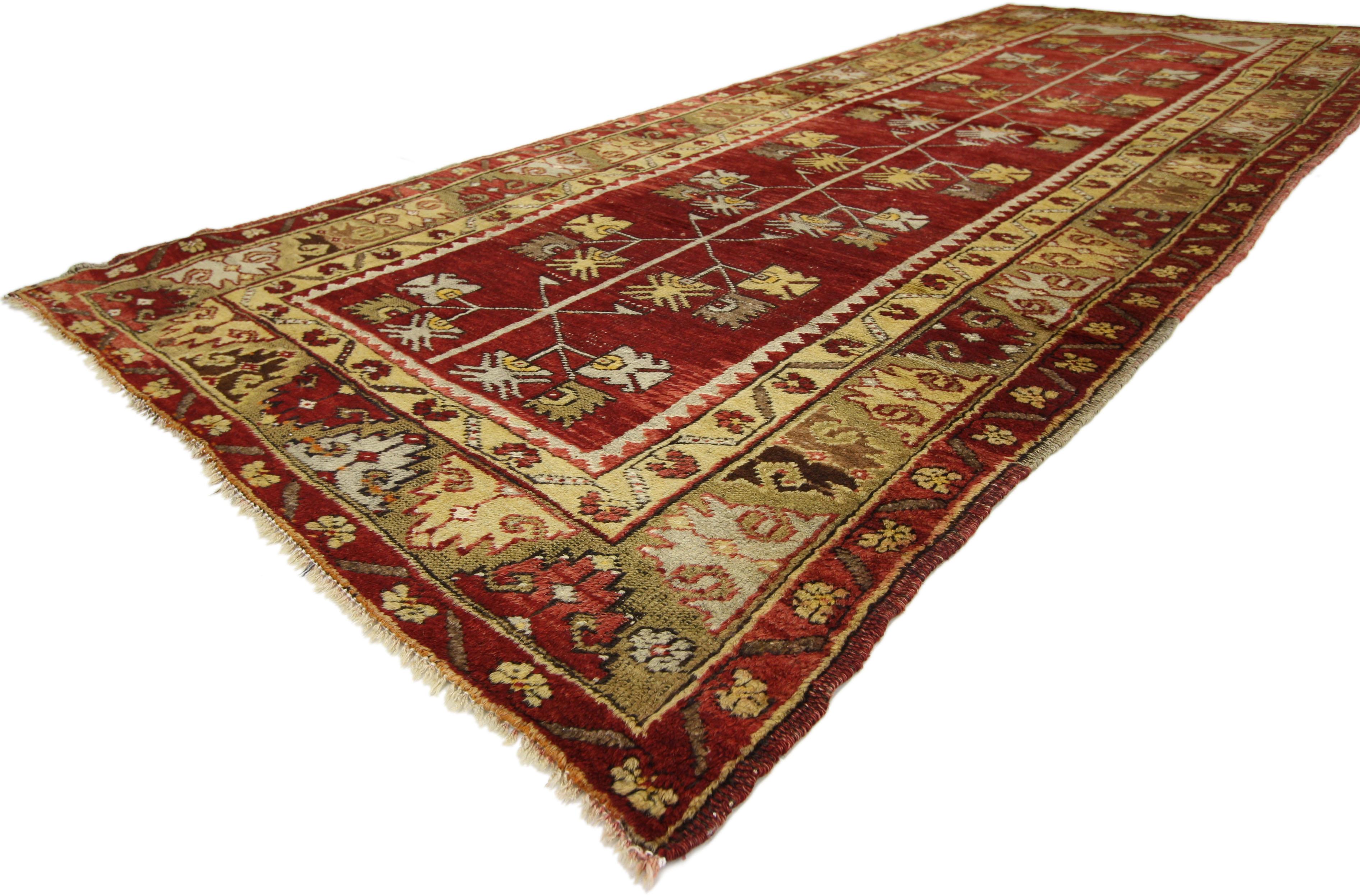 An elaborate Turkish design and rich waves of abrash creates a mesmerizing sense of well-balanced proportions in this vintage Turkish Oushak carpet runner. With its compelling geometric motifs and stylized mihrab niche, this Oushak carpet runner