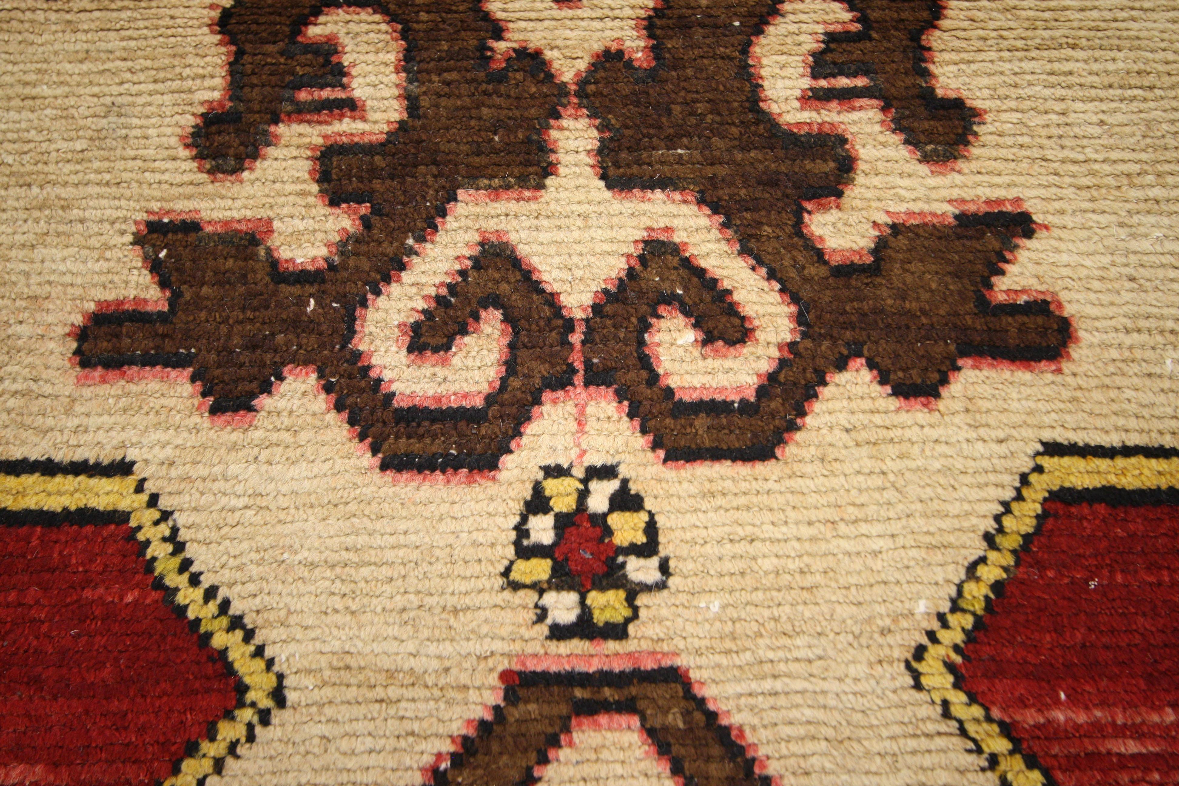 This vintage Turkish Oushak carpet runner with its traditional modern style and impeccable craftsmanship will heighten a room’s sense of place in history. The warm brown border and jewel-tone red field enclose a large-scale medallion with stylized