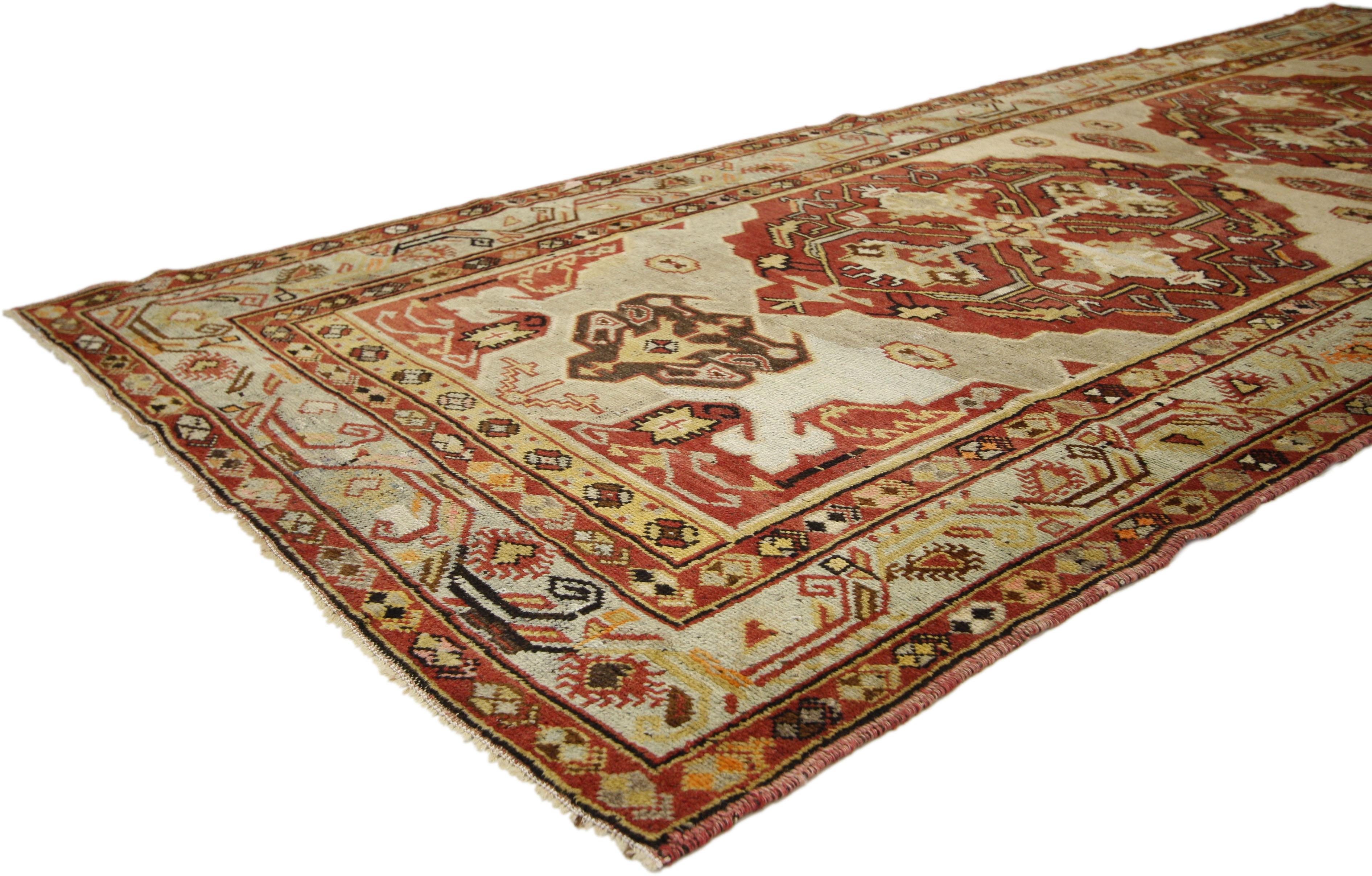 73769, vintage Turkish Oushak runner with Tribal design and rustic style, hallway runner. Hand knotted wool vintage Turkish Oushak runner featuring two large geometric medallions and tribal motifs in an open abrashed beige field surrounded by a