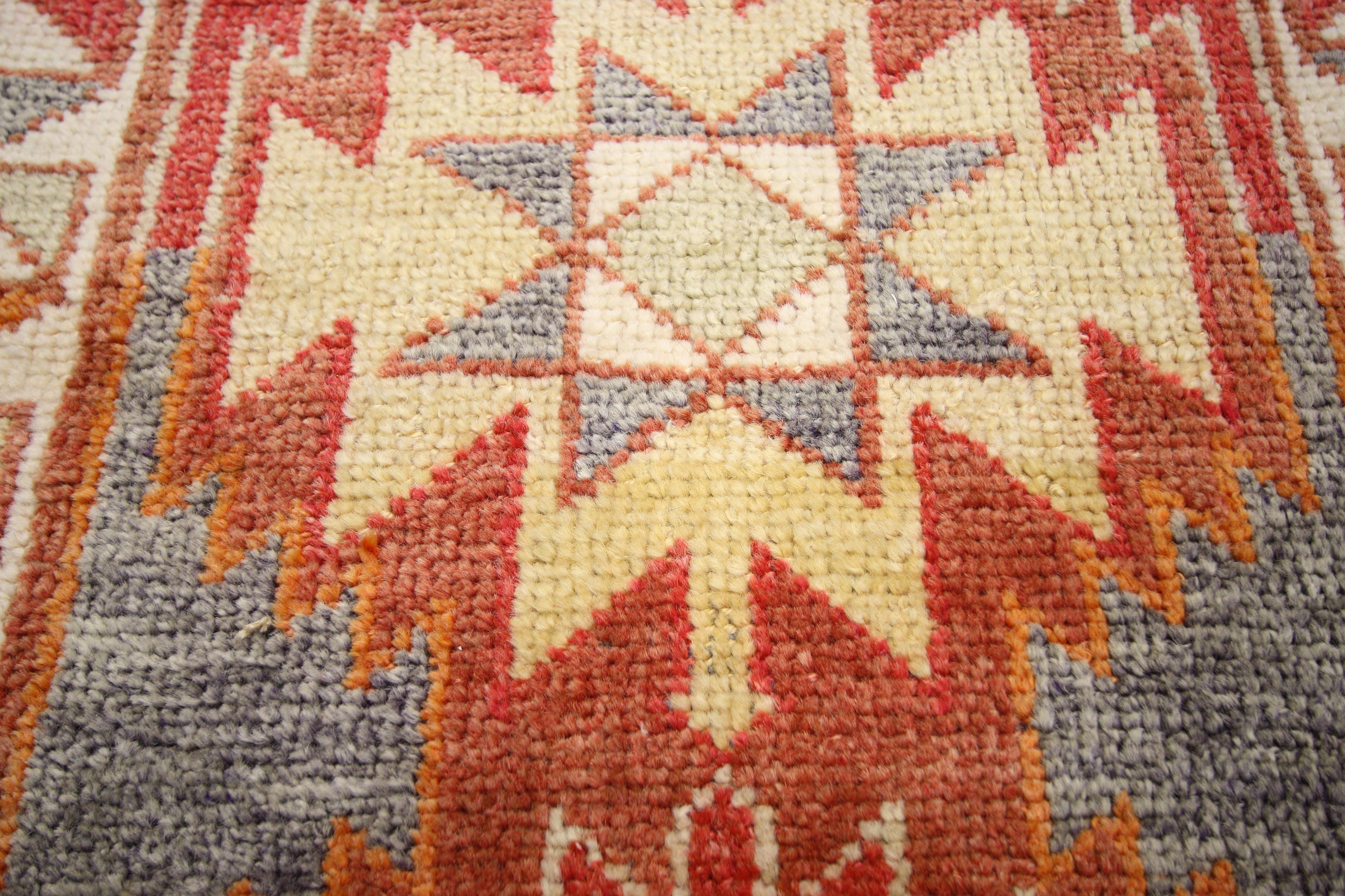 52313, vintage Turkish Oushak runner with tribal style, long hallway runner. This hand-knotted wool vintage Turkish Oushak runner features angular Bergama-style medallions in alternating colors along the center of an abrashed terra cotta and brick