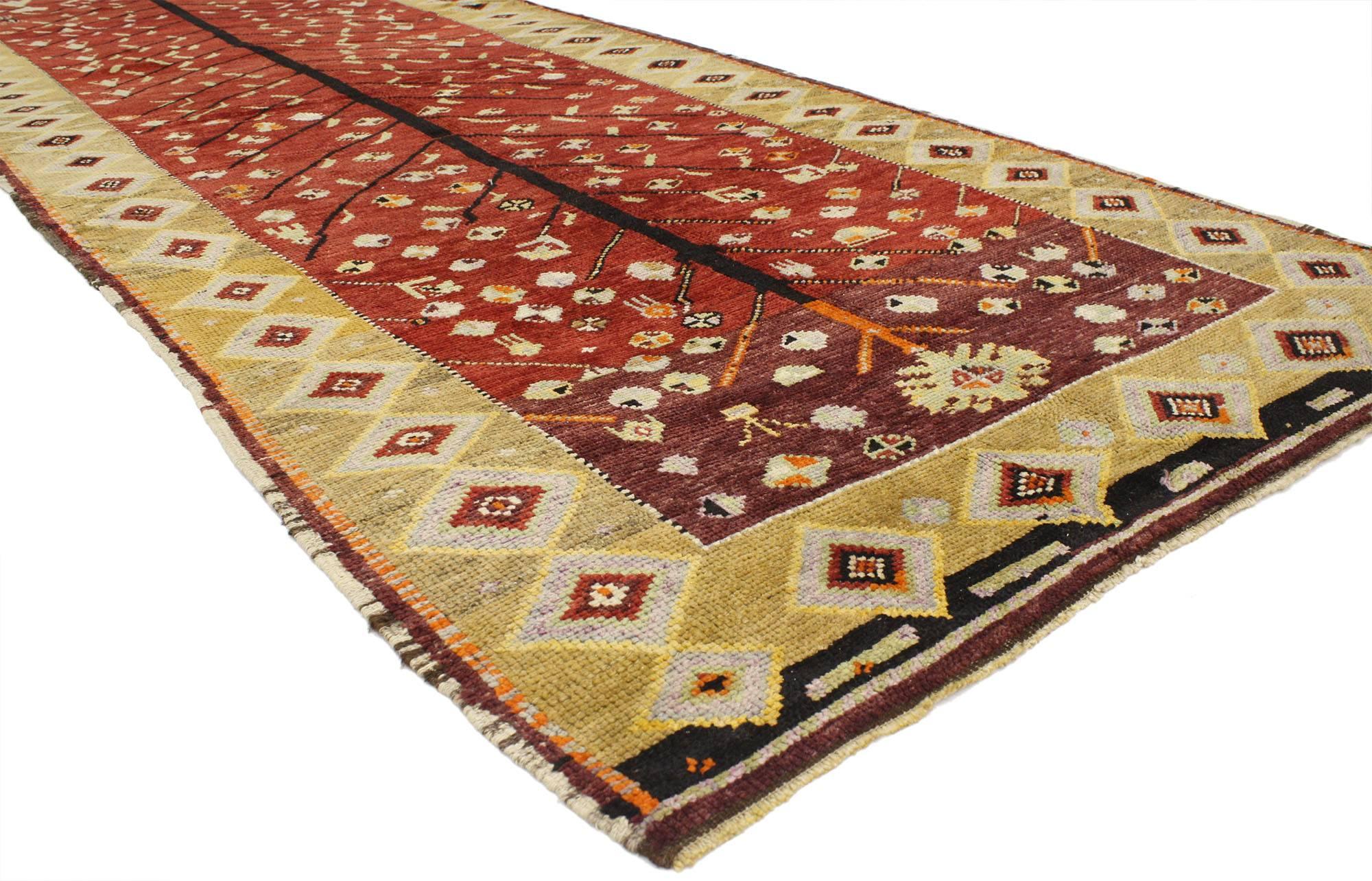 52252, vintage Turkish Oushak runner with Tribal style. This hand-knotted wool vintage Turkish Oushak runner features a tree of life design on an abrashed scarlet red and burgundy field. A variety of symbols and motifs surround the tree including