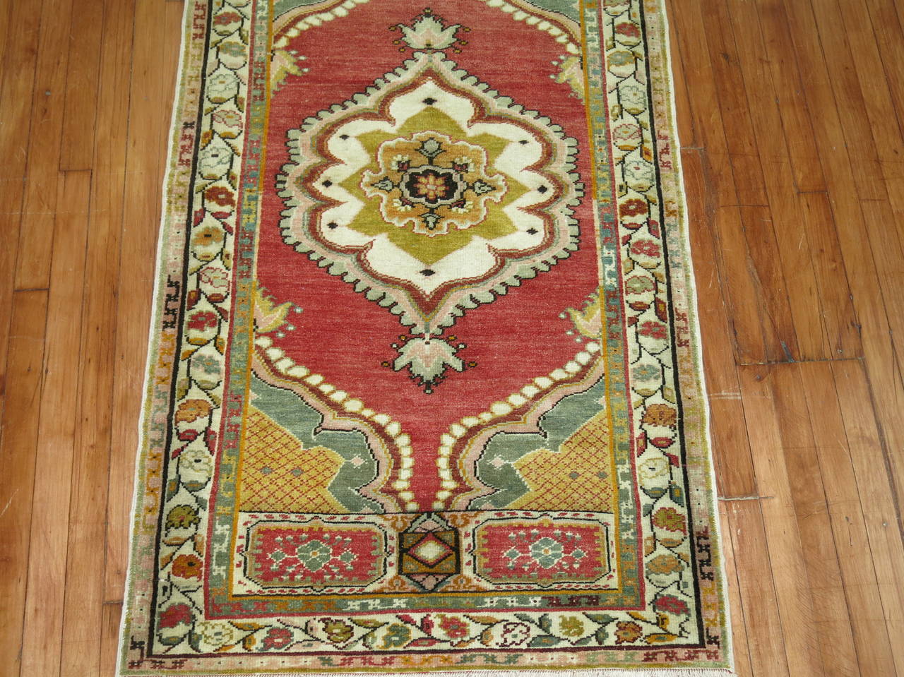 Vintage rug from Oushak with elaborate center medallion and border. Red field, sage green and ivory dominant accents,

circa 1930, measures: 3'1