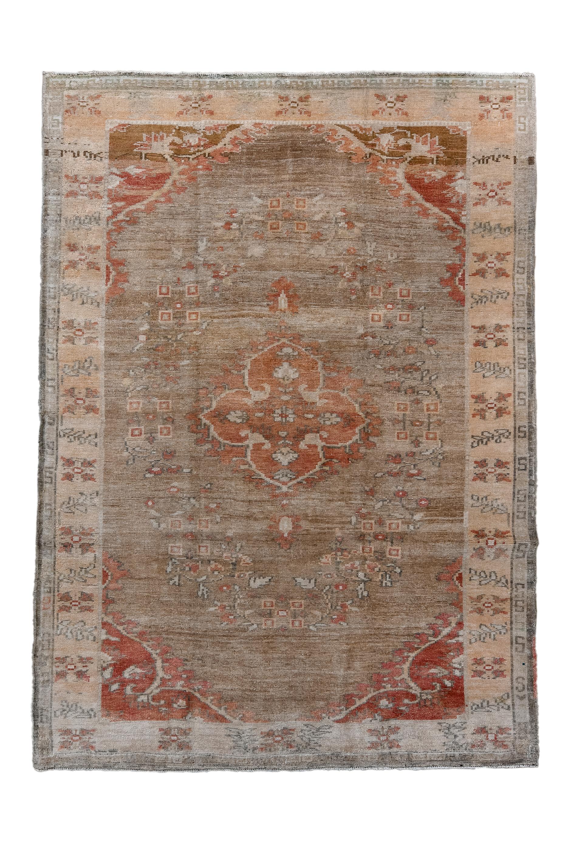 The abrashed terra cotta field shows a rust, four lobe medallion within a floral wreath, and set off by dark red corners. Straw border with leaf sprays and four radiating flower squares. Moderate/coarse weave.

Rug Size
6'10x9'6