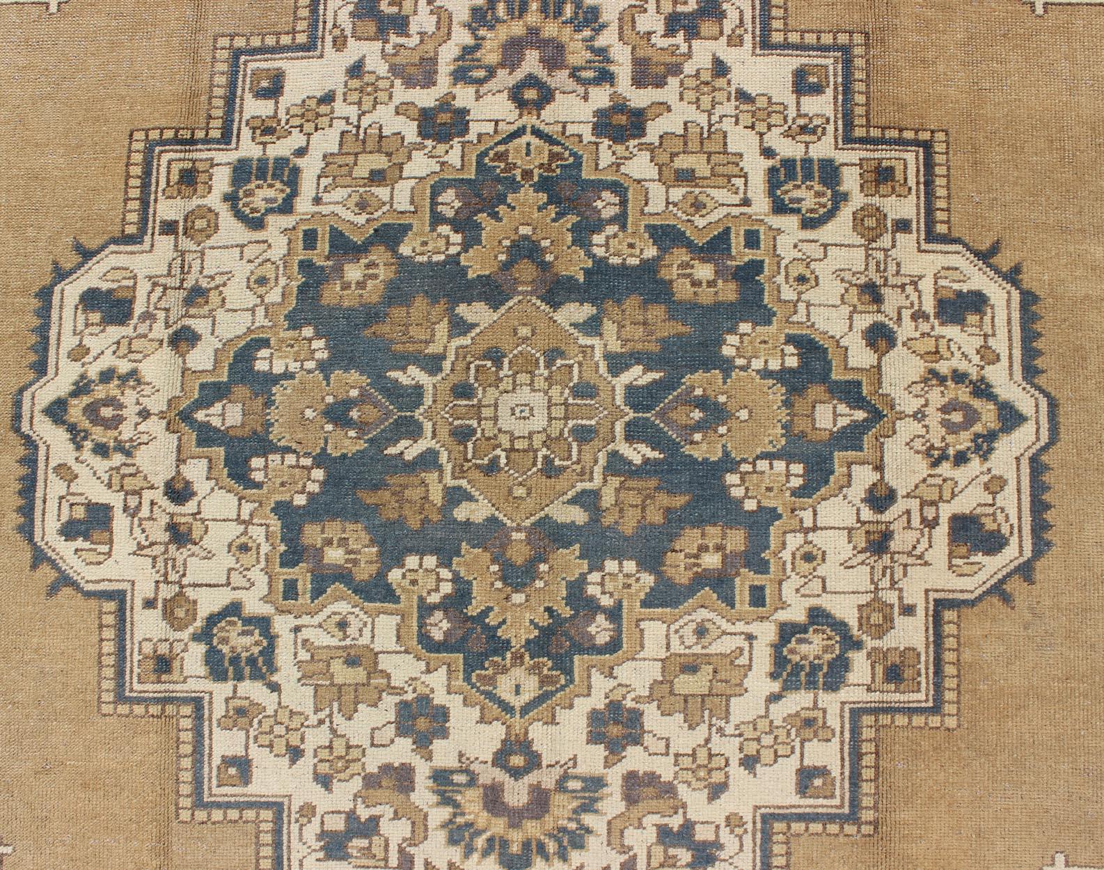 Measures: 6'10'' x 11'5''

Characterized by a comely and highly representative Oushak composition, this vintage carpet beautifully communicates the finer characteristics of Oushak rug weaving. The stylized medallion holds floral motifs, as well as